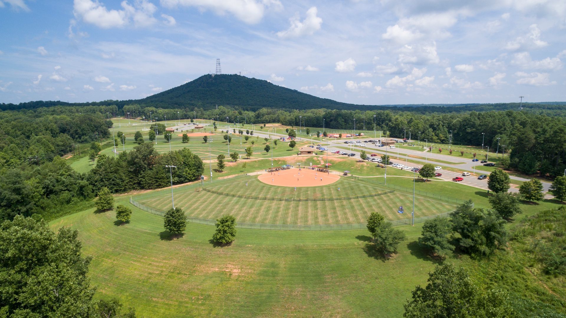 An aerial view of a baseball field with a mountain in the background.