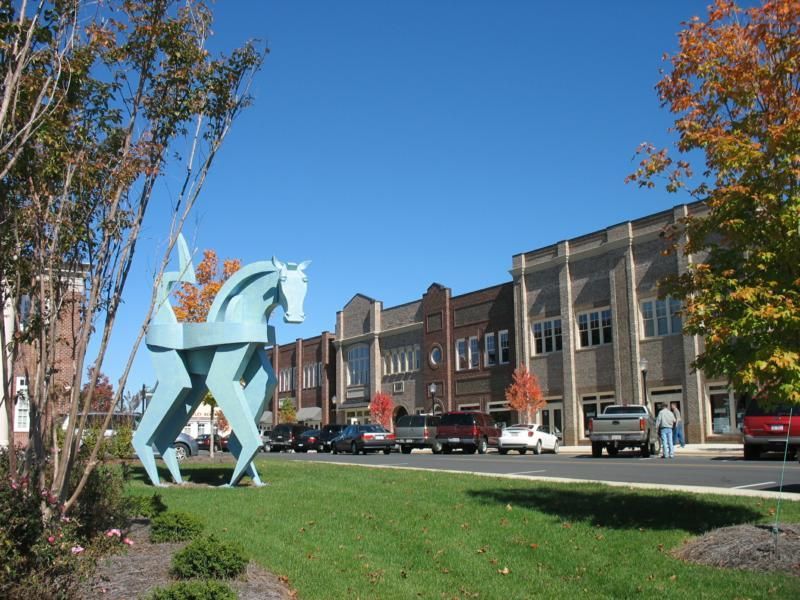 A statue of a man riding a horse in front of a building