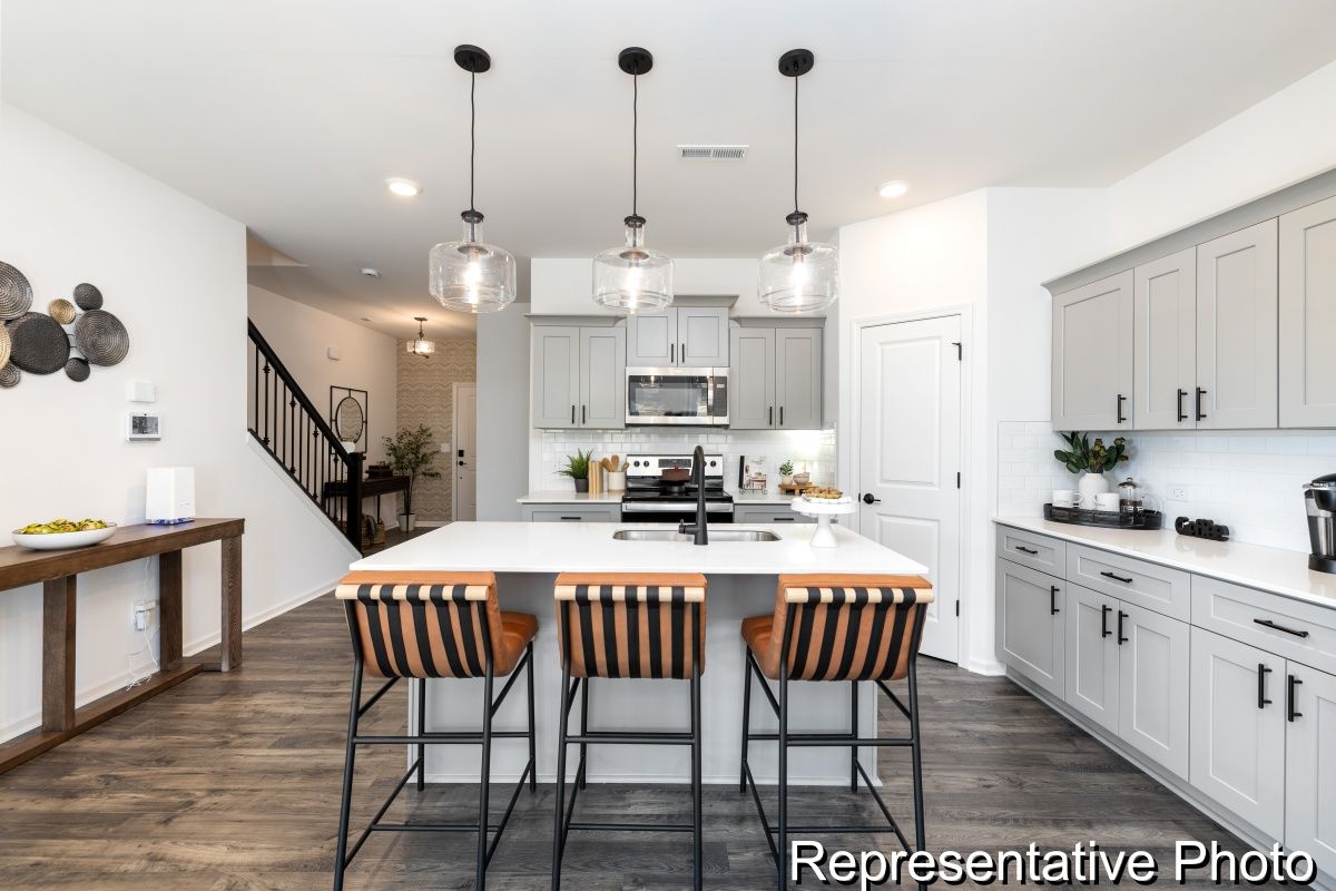 It is a representative photo of a kitchen with a large island.