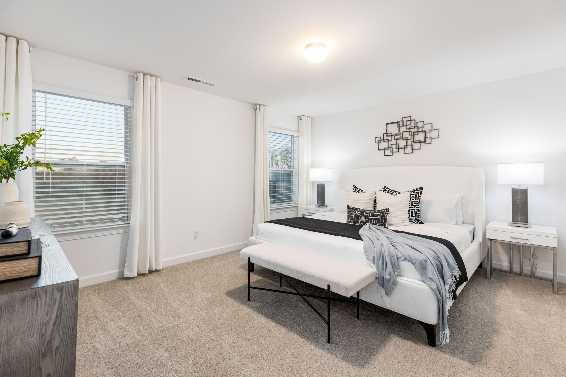 A bedroom with a king size bed and a bench.