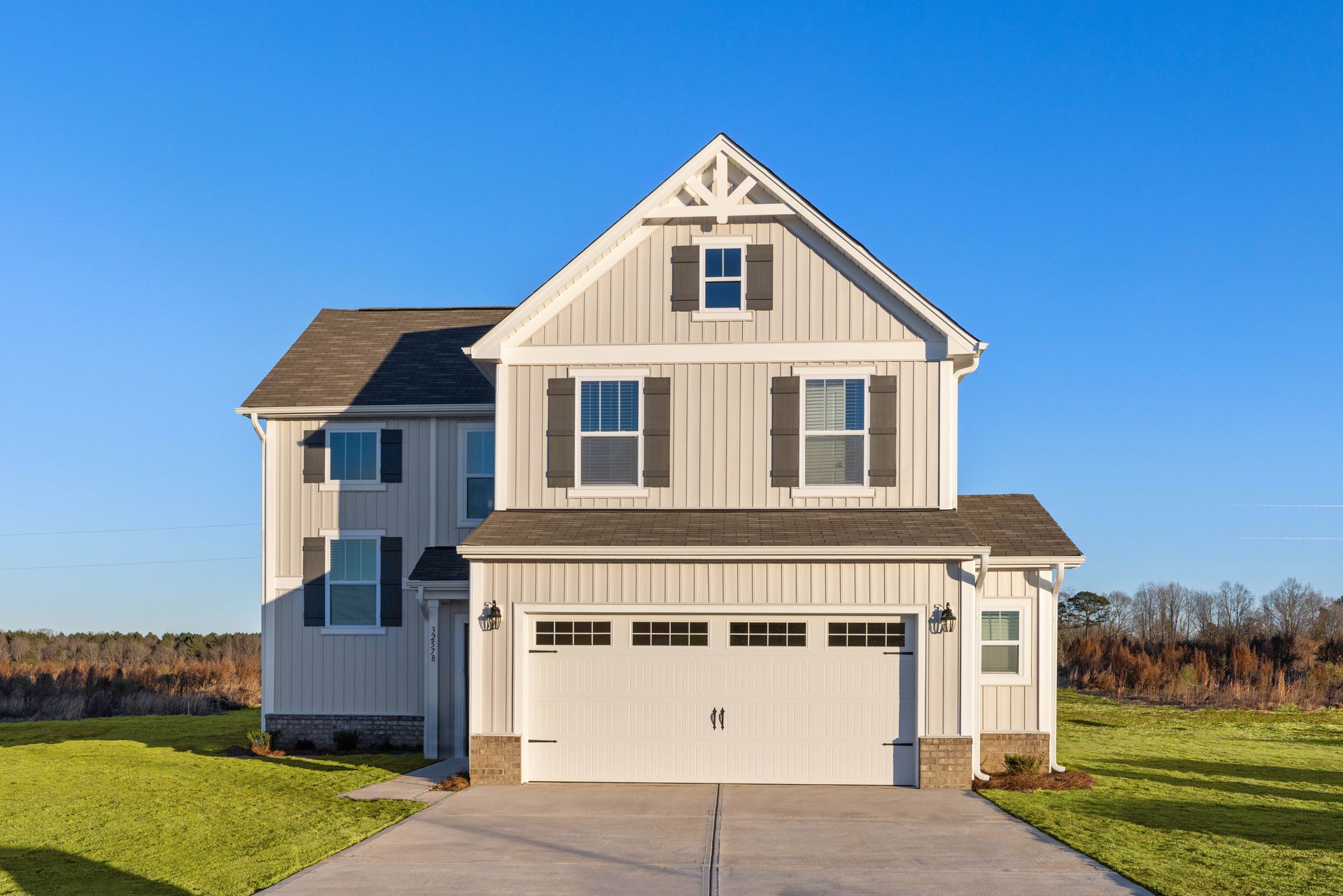 A large white house with a large garage and a driveway.