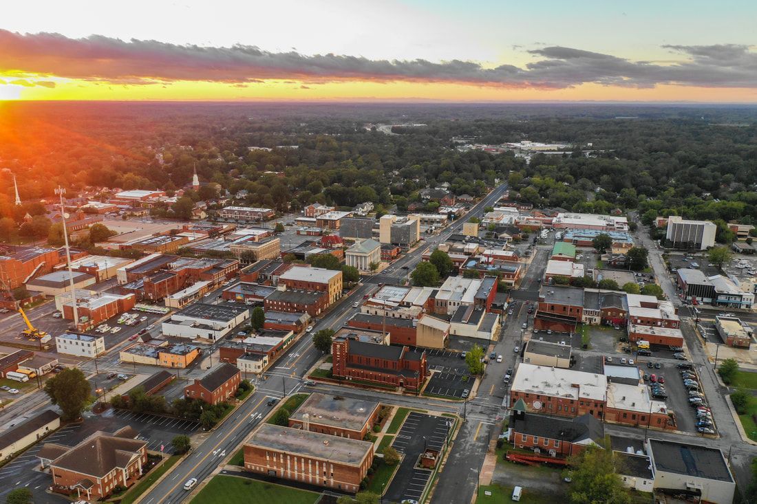 an aerial view of a small town with a sunset in the background