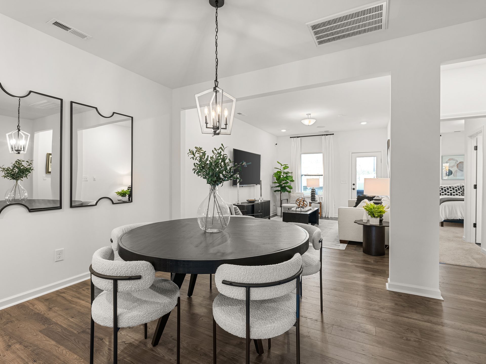 A dining room with a round table and chairs and a chandelier.