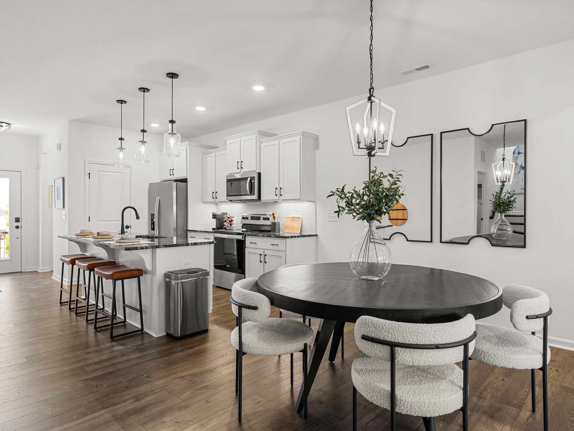 A kitchen and dining room with a round table and chairs.