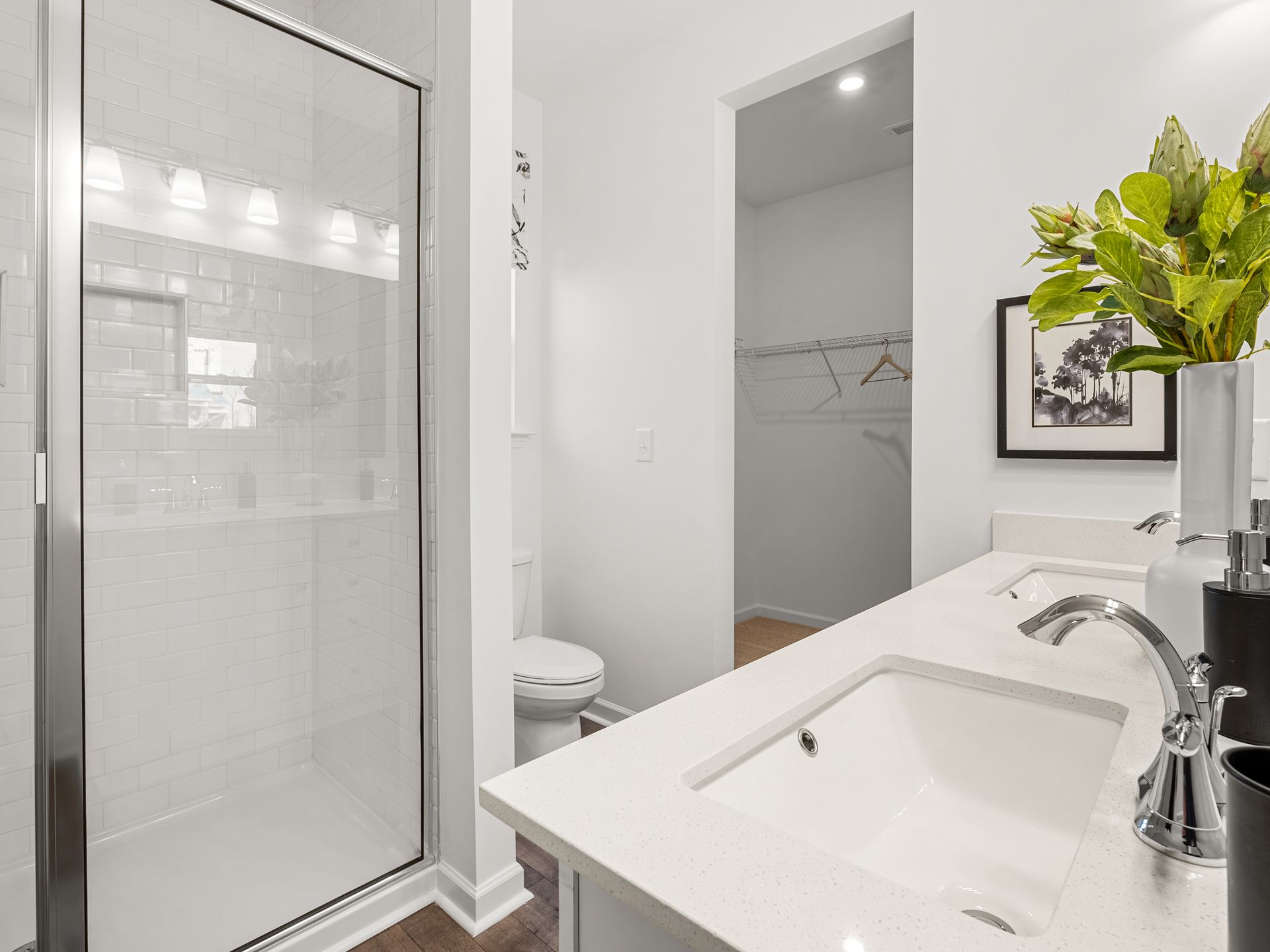 A bathroom with a sink , toilet and walk in shower.