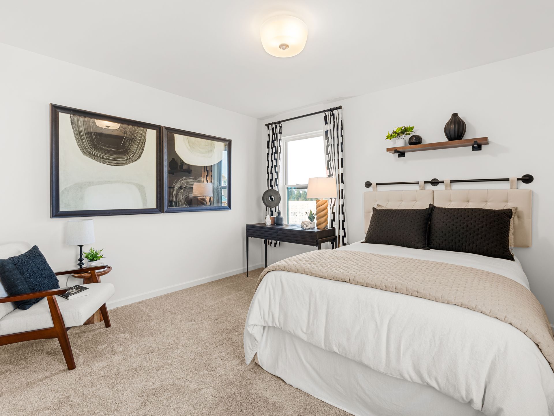 A bedroom with a bed , chair , desk and mirrors.