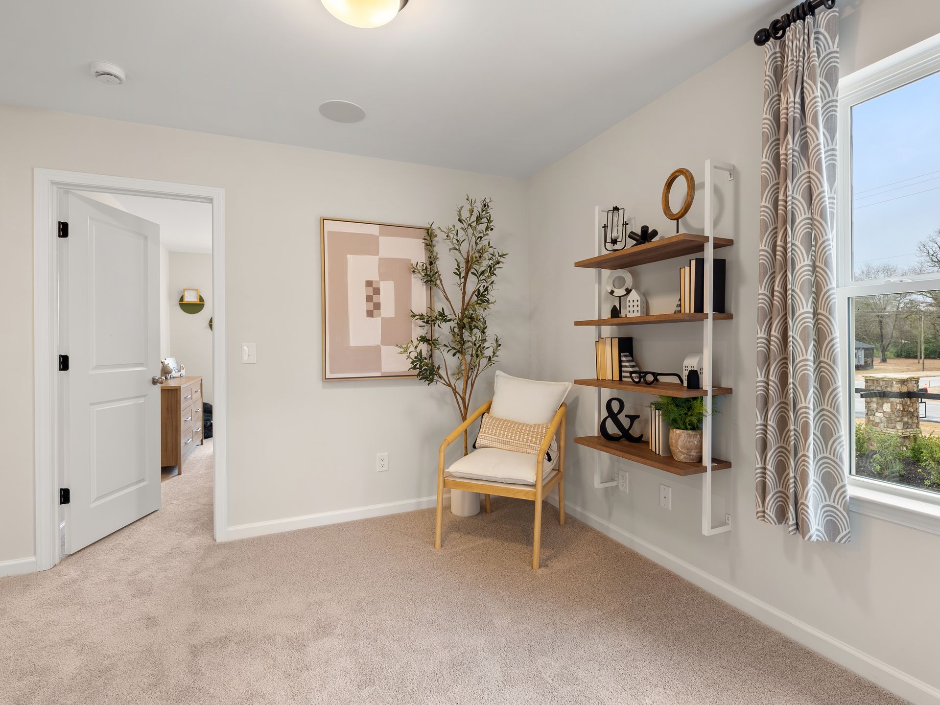 A bedroom with a chair , shelves , and a window.