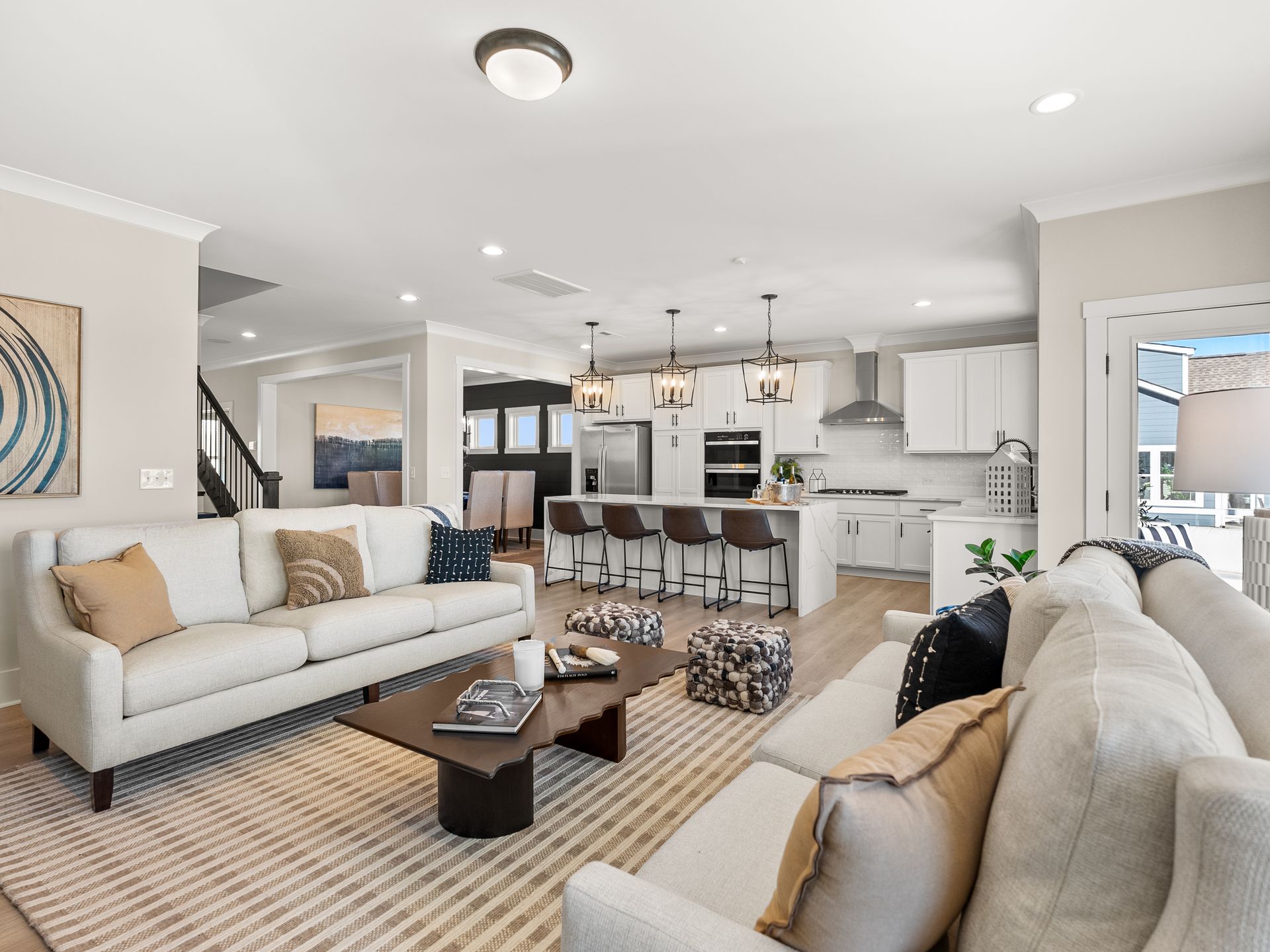 A living room with two couches , a coffee table , and a kitchen.