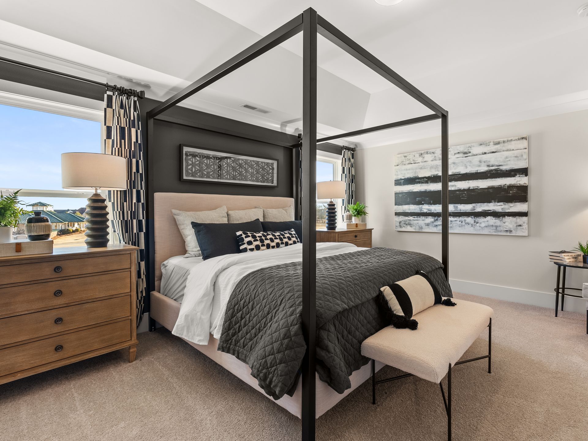 A bedroom with a canopy bed and a bench.