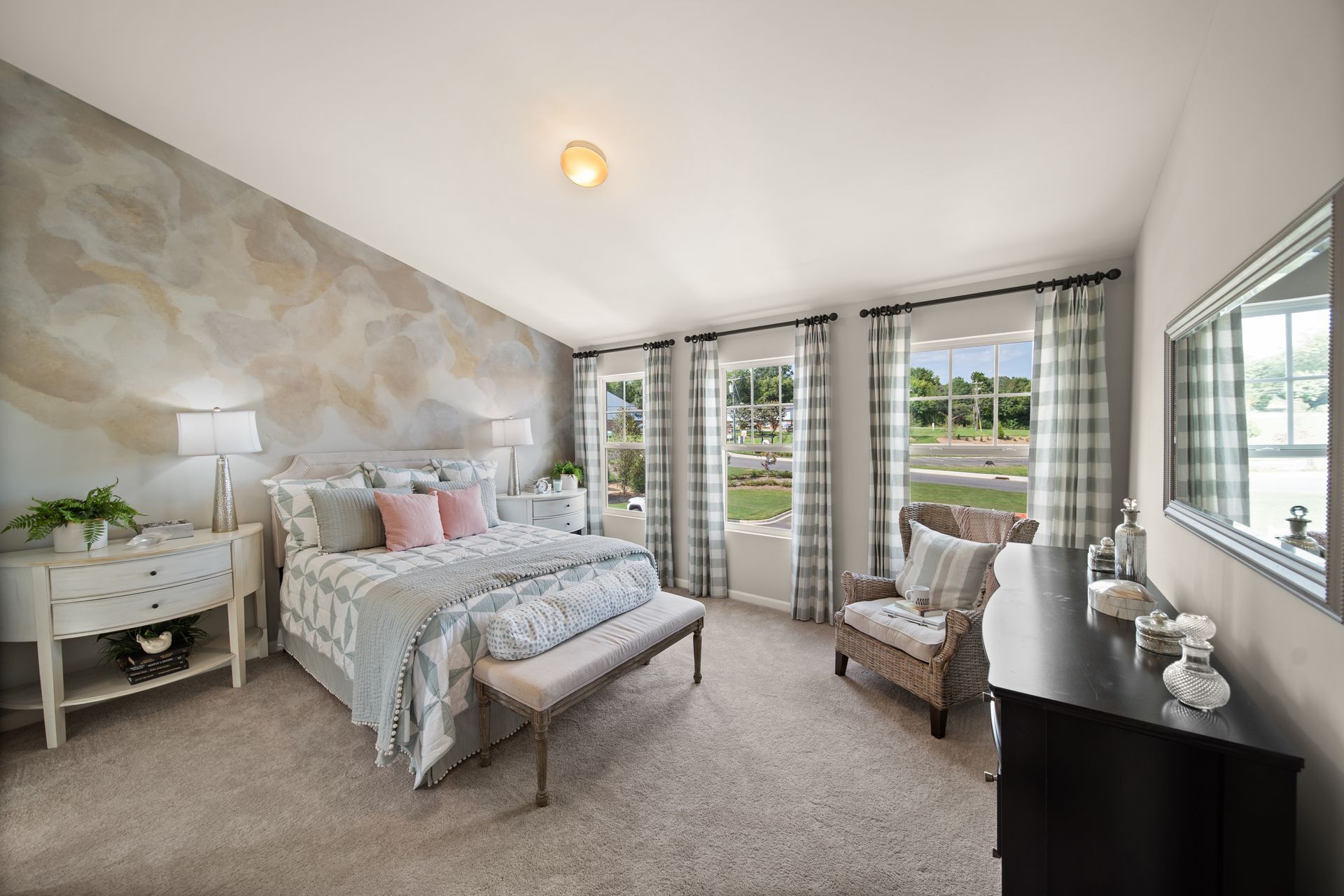 a bedroom with a bed , chair , dresser and mirror .