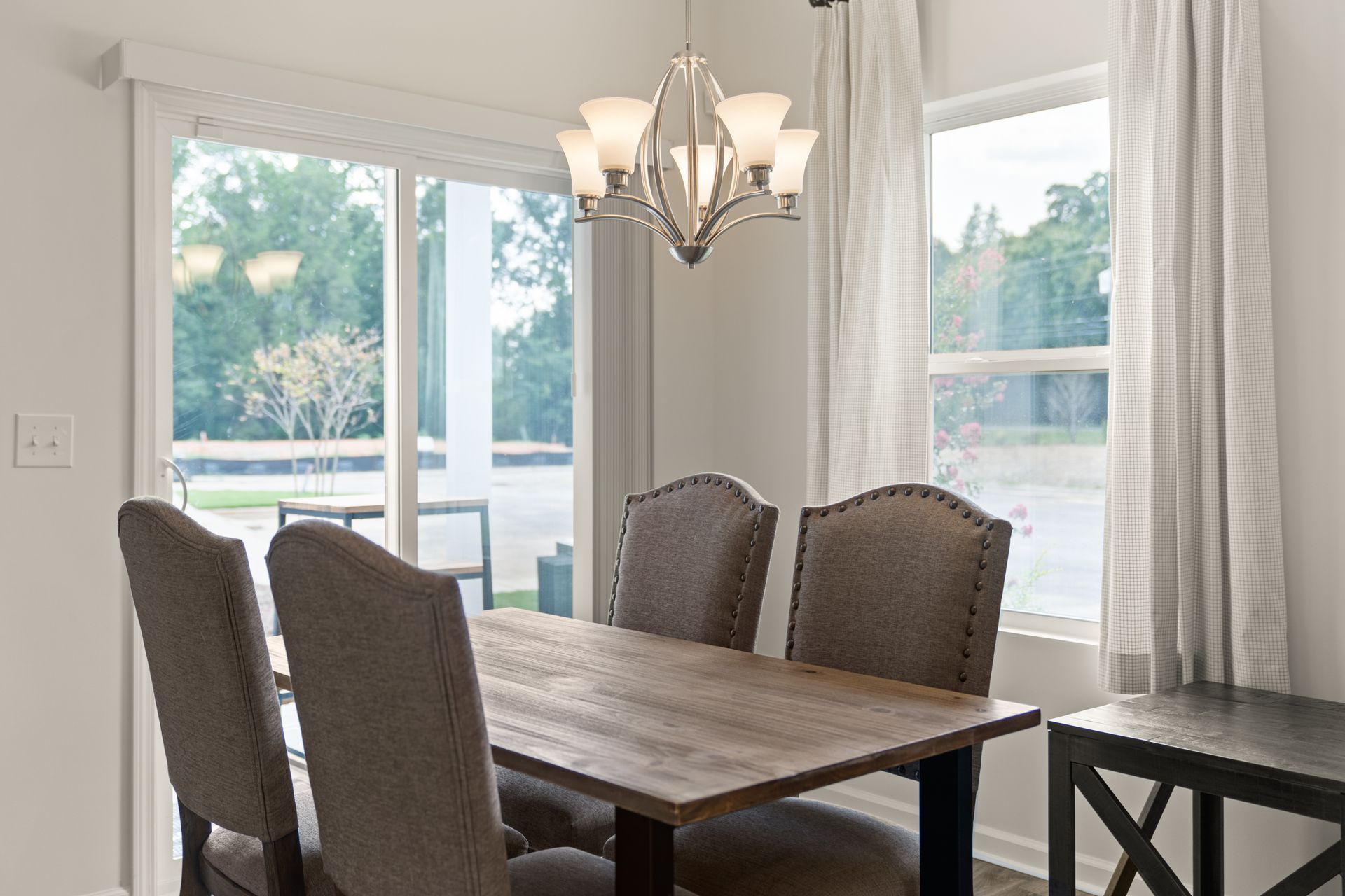 a dining room with a wooden table and chairs and a chandelier .
