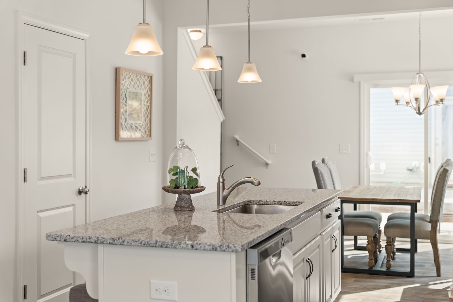 a kitchen with a granite counter top , sink , dishwasher , and dining table .