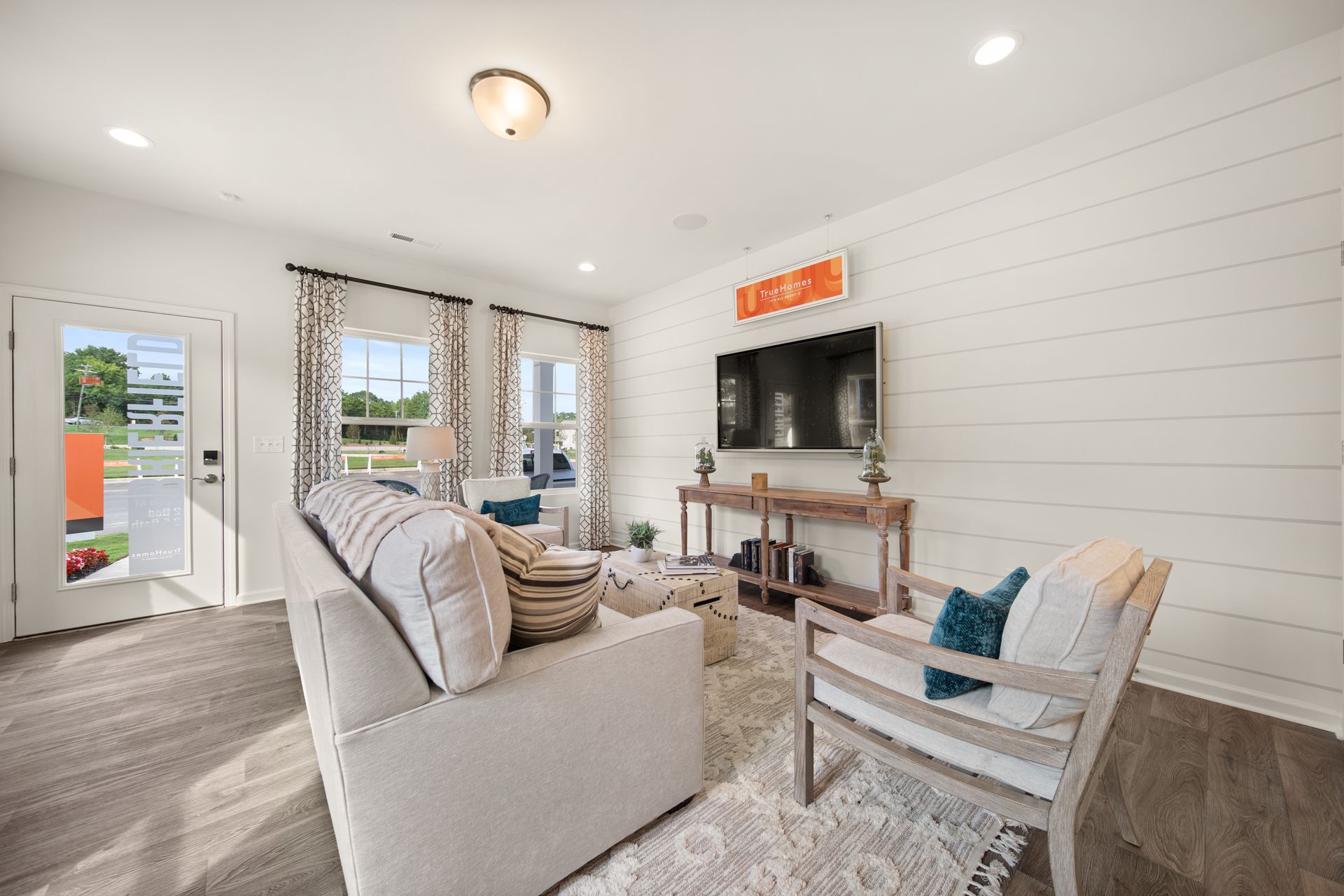 a living room with a couch , chair , and television .