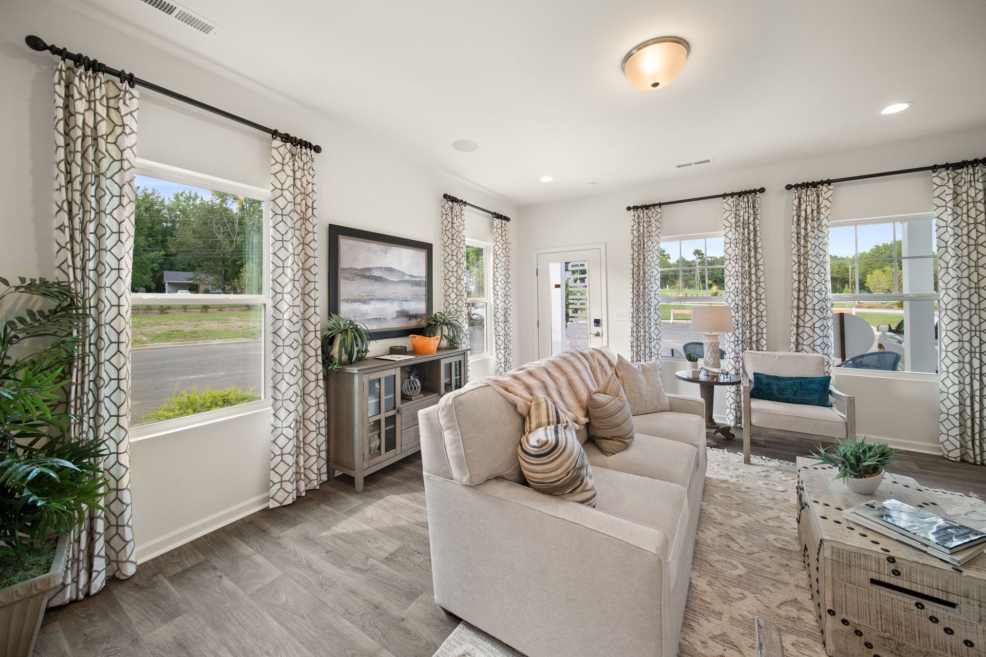 a living room with a couch , chairs , and a television .