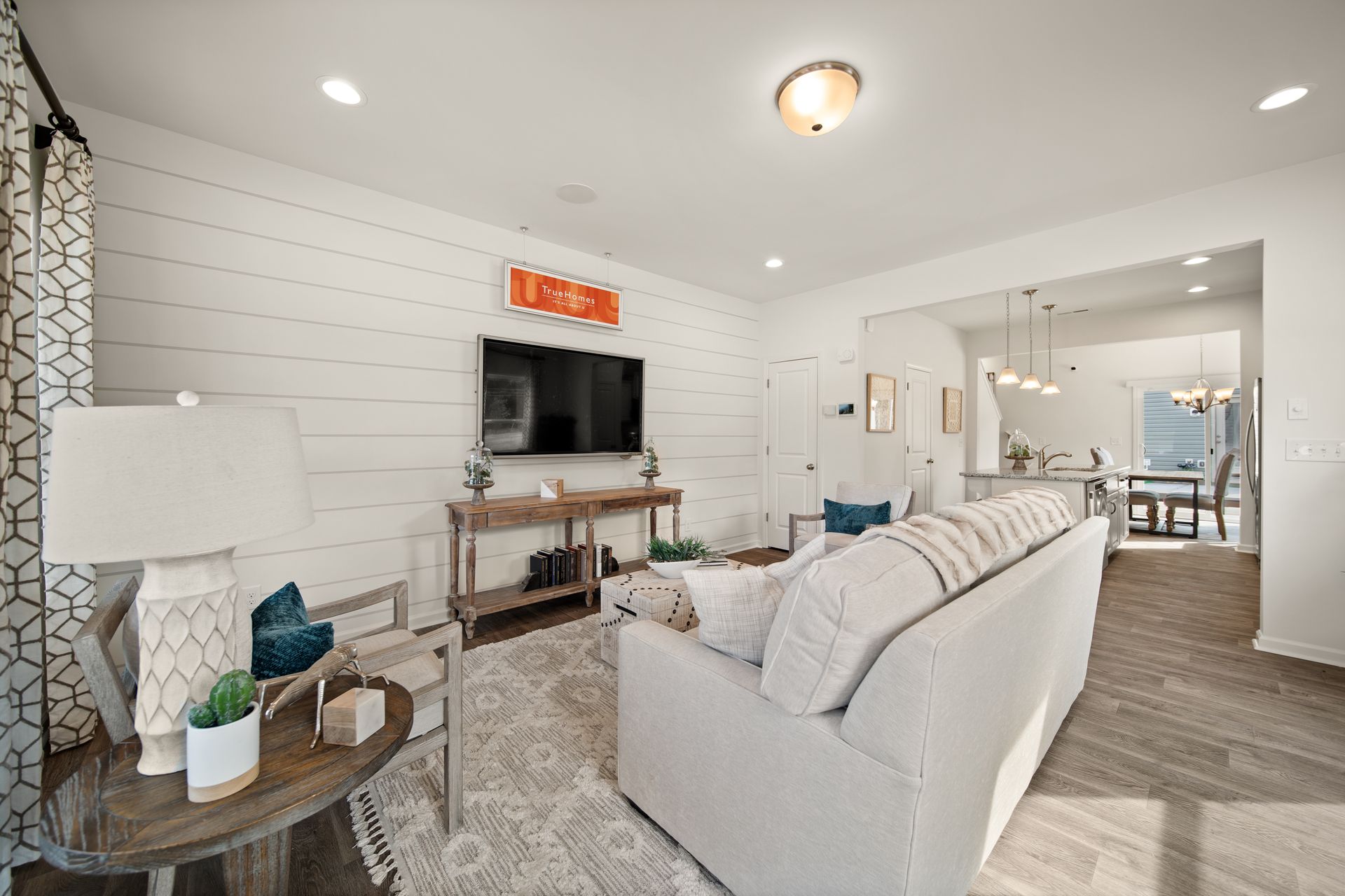 a living room with a white couch and a flat screen tv on the wall .