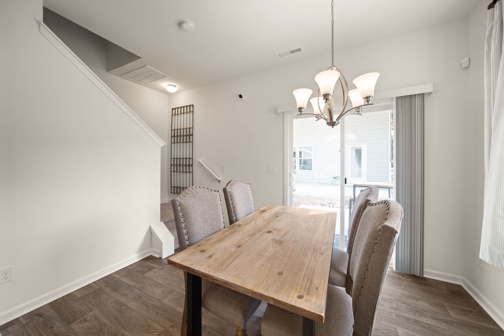 a dining room with a wooden table and chairs and a chandelier .