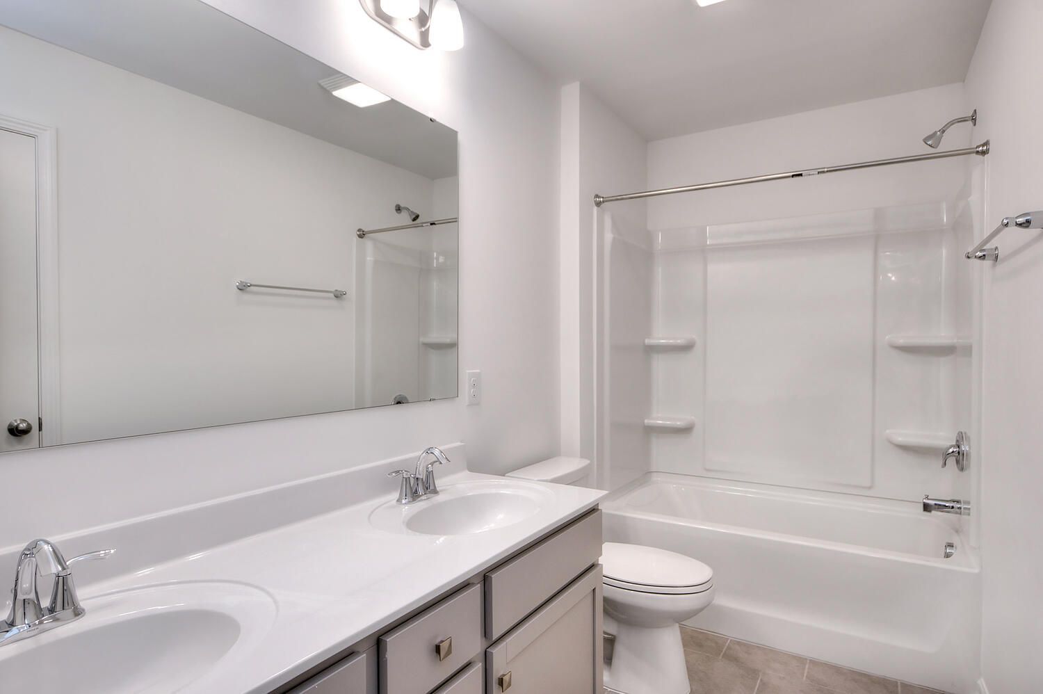 A bathroom with two sinks , a toilet , and a bathtub.