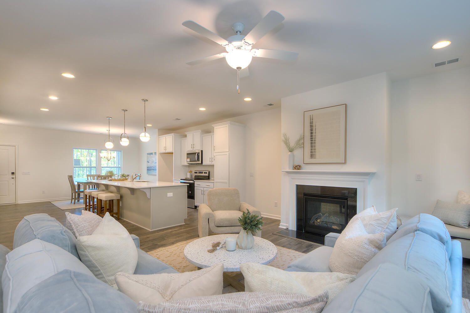 A living room filled with furniture and a fireplace with a ceiling fan.