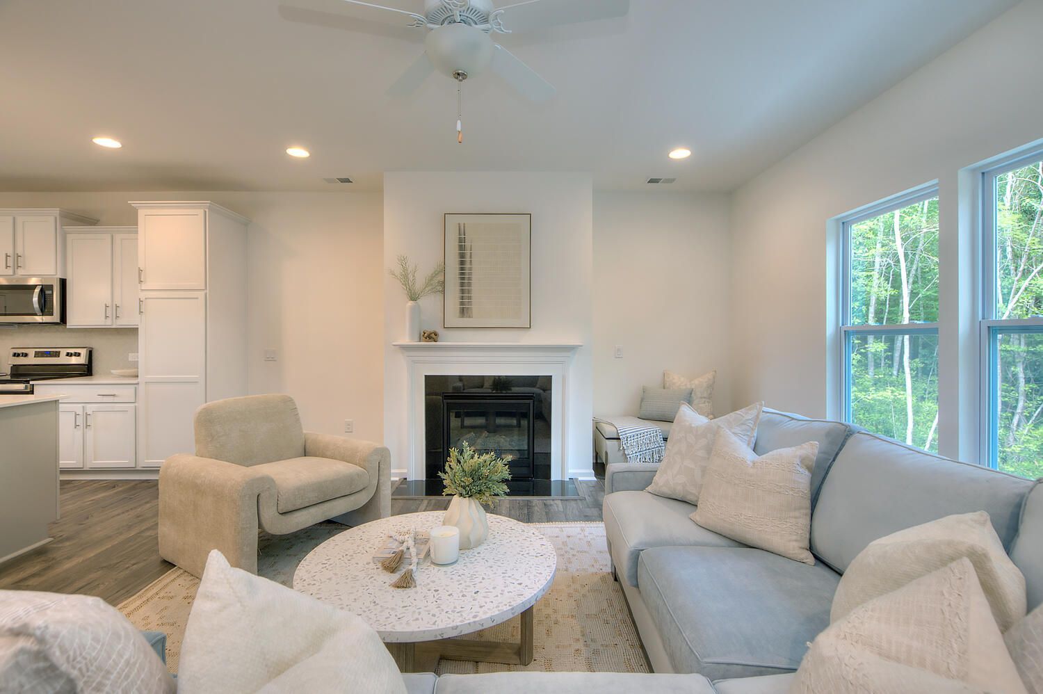 A living room with a couch , chair , coffee table and fireplace.