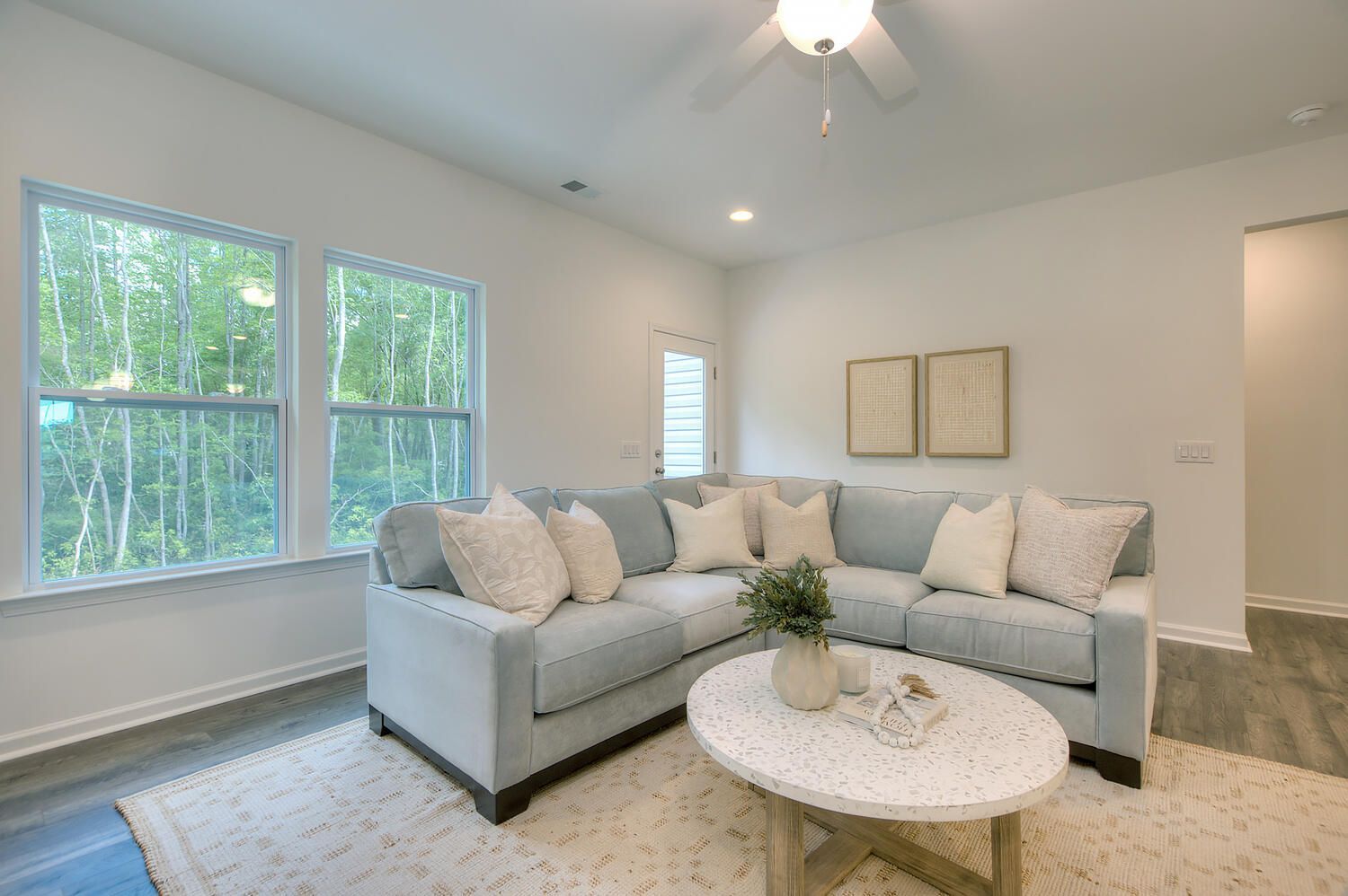 A living room with a couch , coffee table , and ceiling fan.