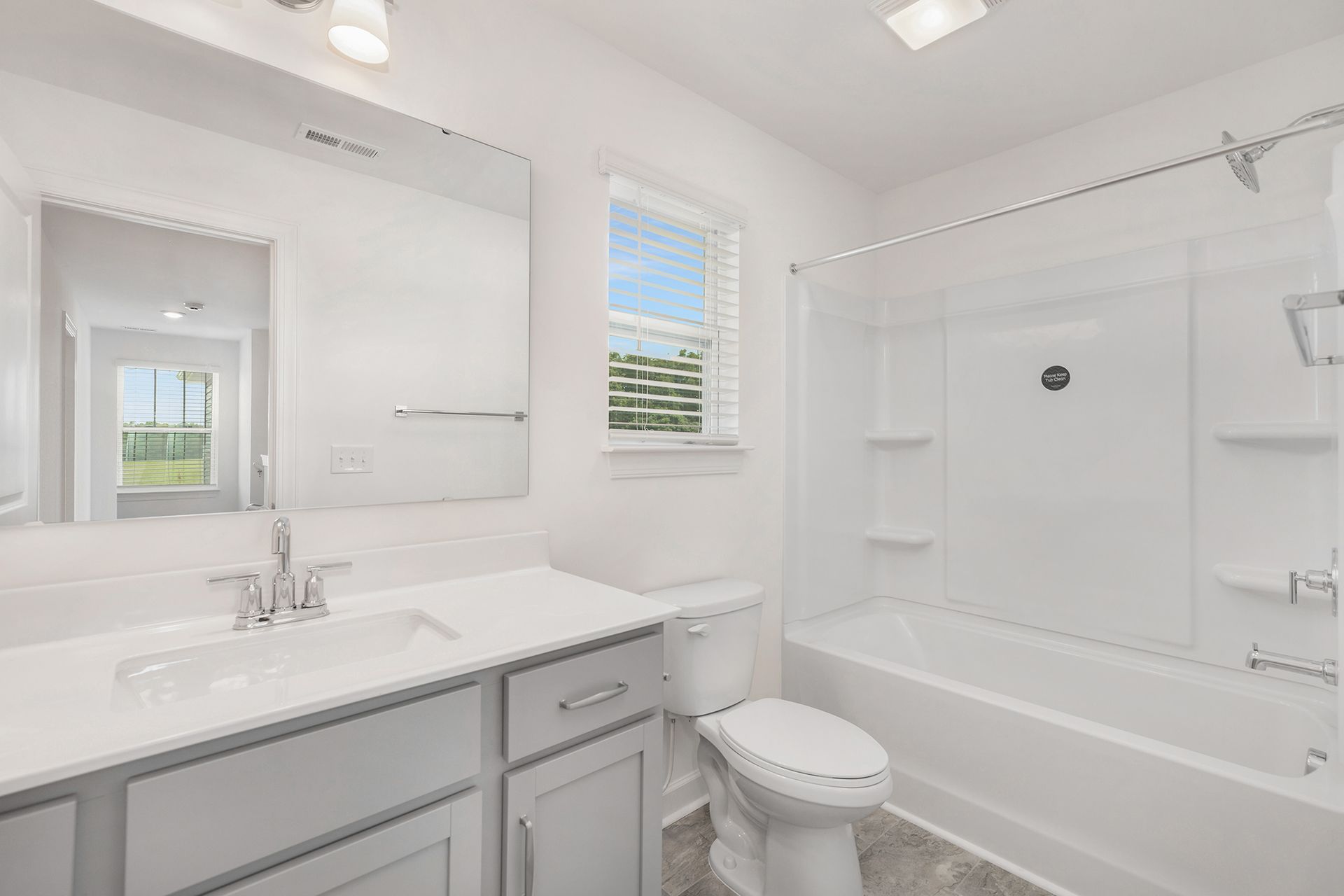 A bathroom with a sink , toilet , bathtub and mirror.