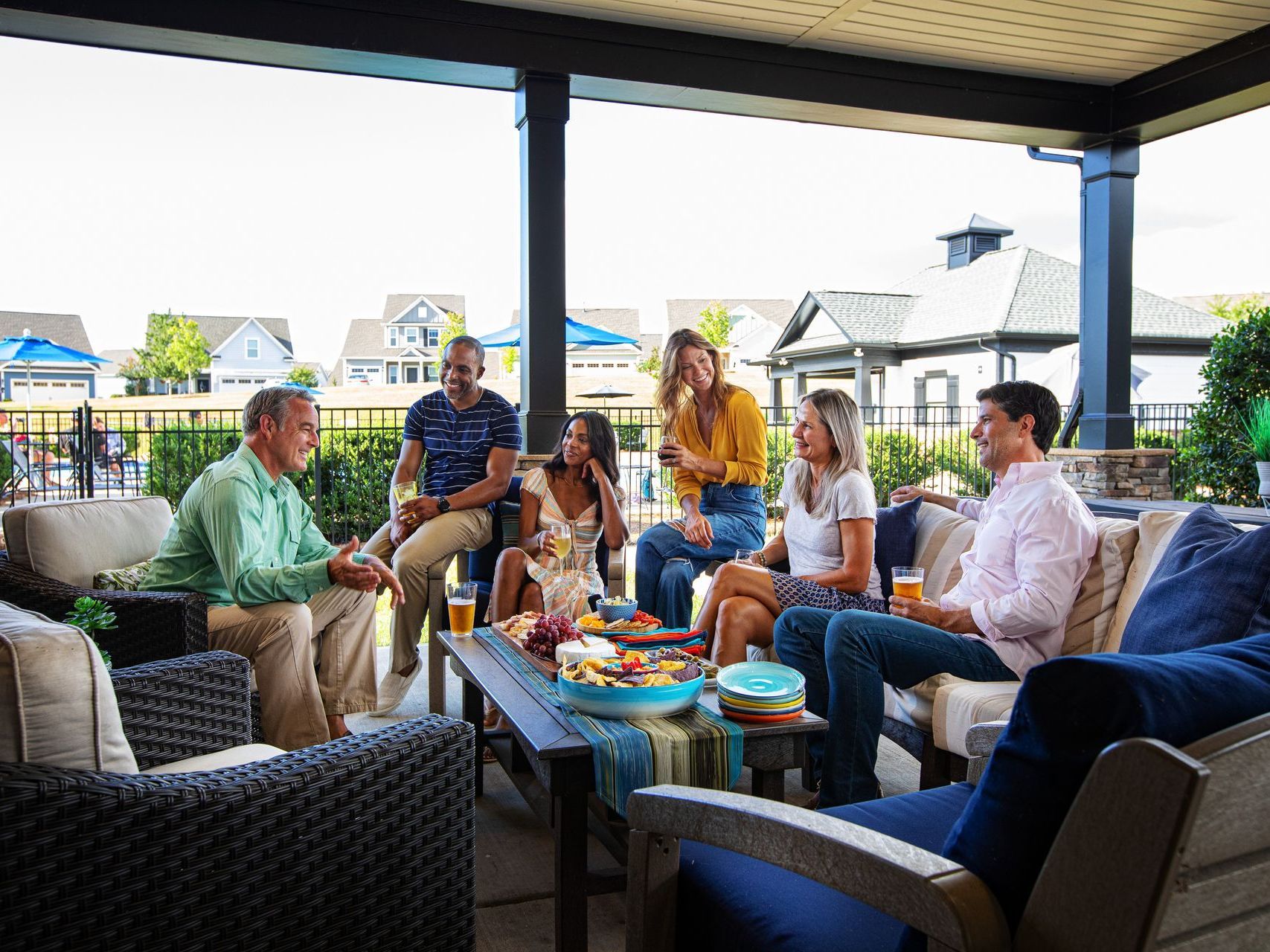 a group of people are sitting around a table on a patio .