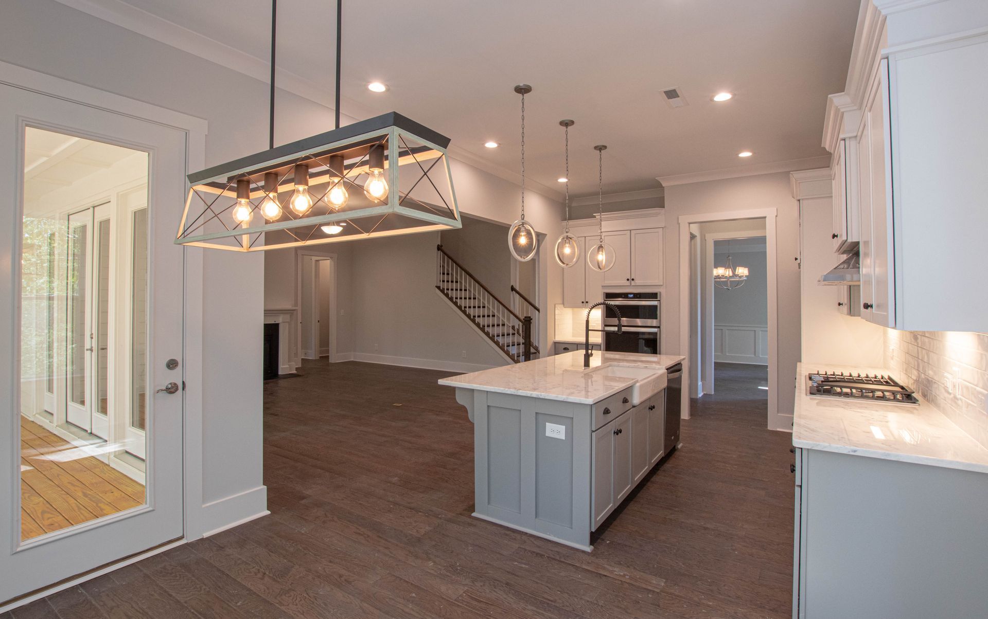 A kitchen with a large island and a chandelier hanging from the ceiling.