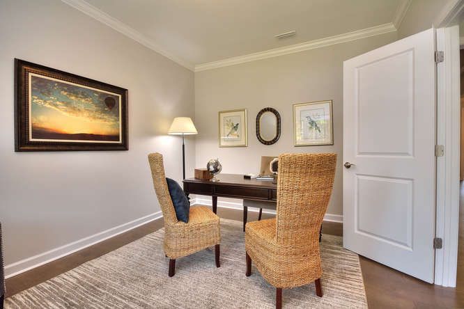 A home office with two chairs and a desk.