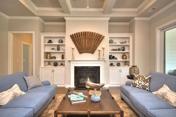 A living room with two blue couches and a fireplace