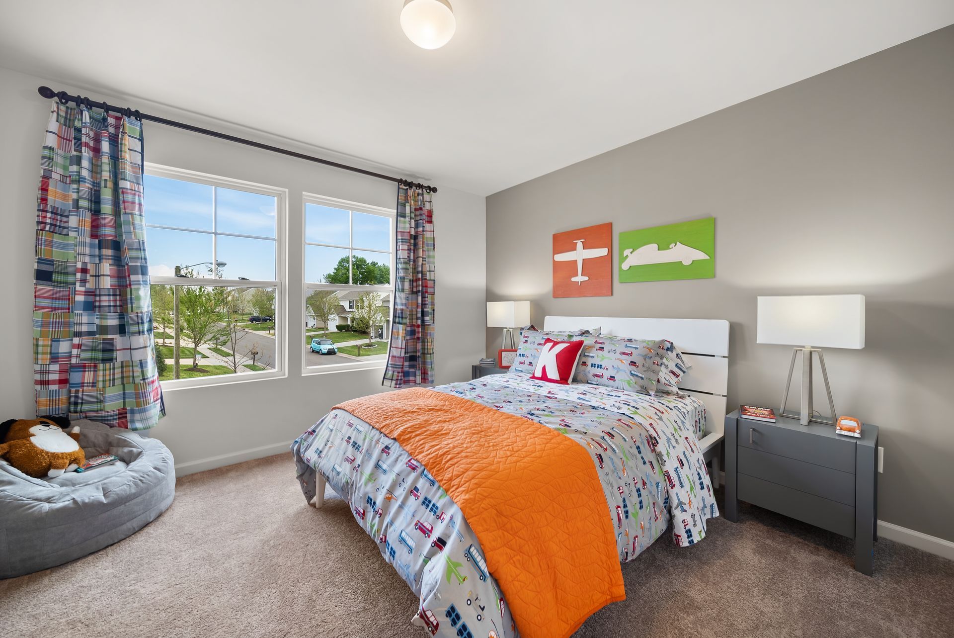 A bedroom with a bed , nightstand , and two windows.