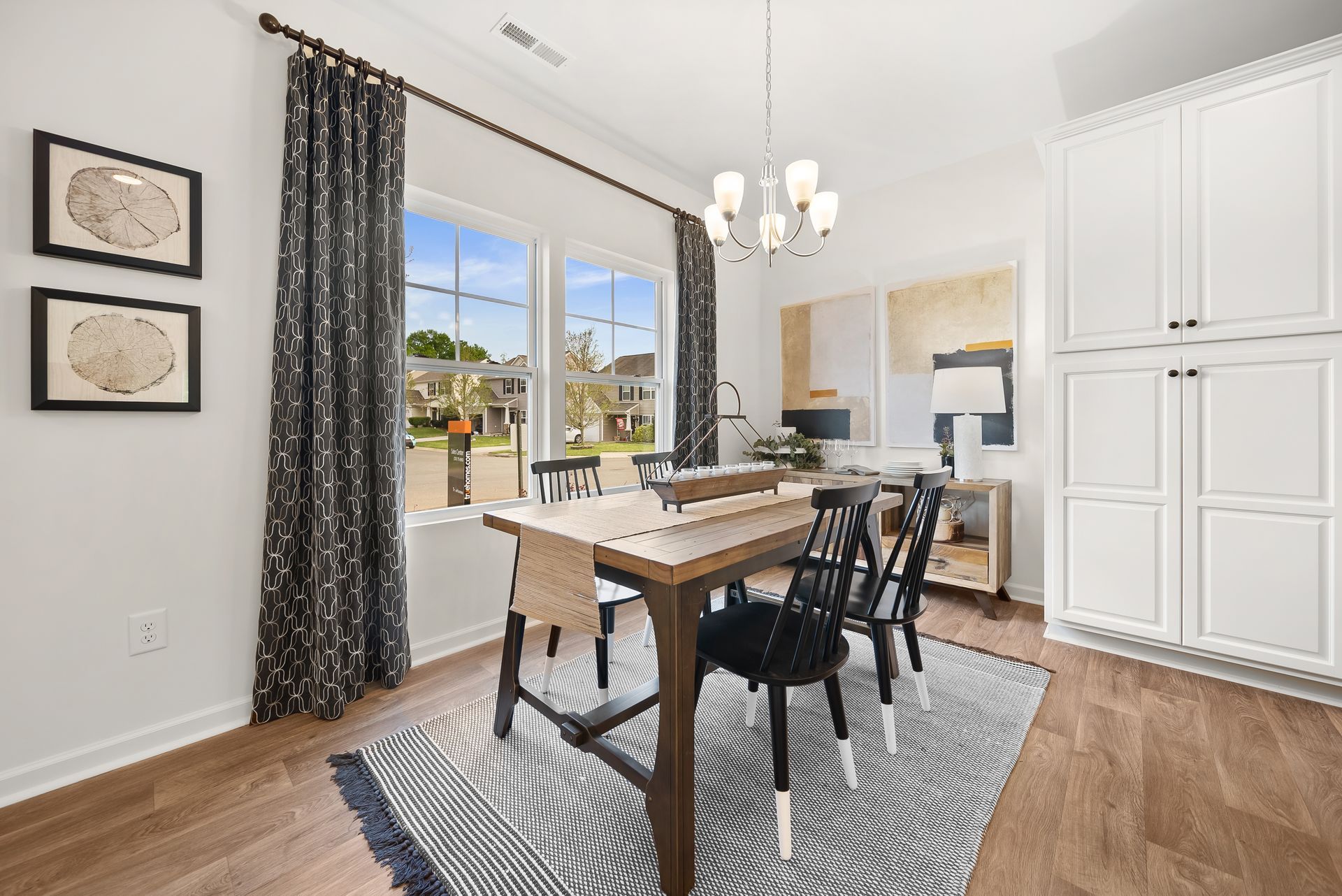 A dining room with a table and chairs and a rug.
