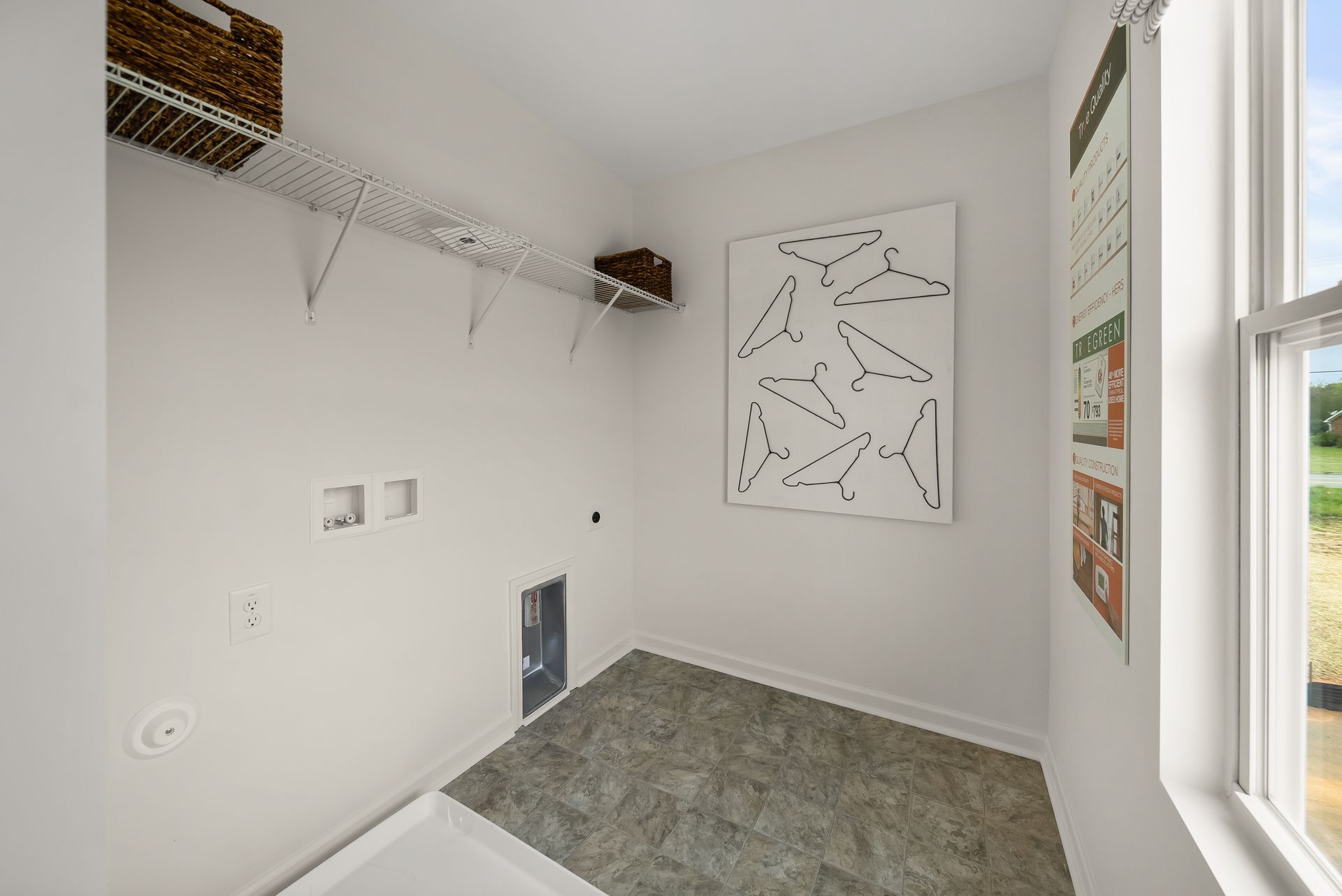 A laundry room with a painting on the wall and a window.