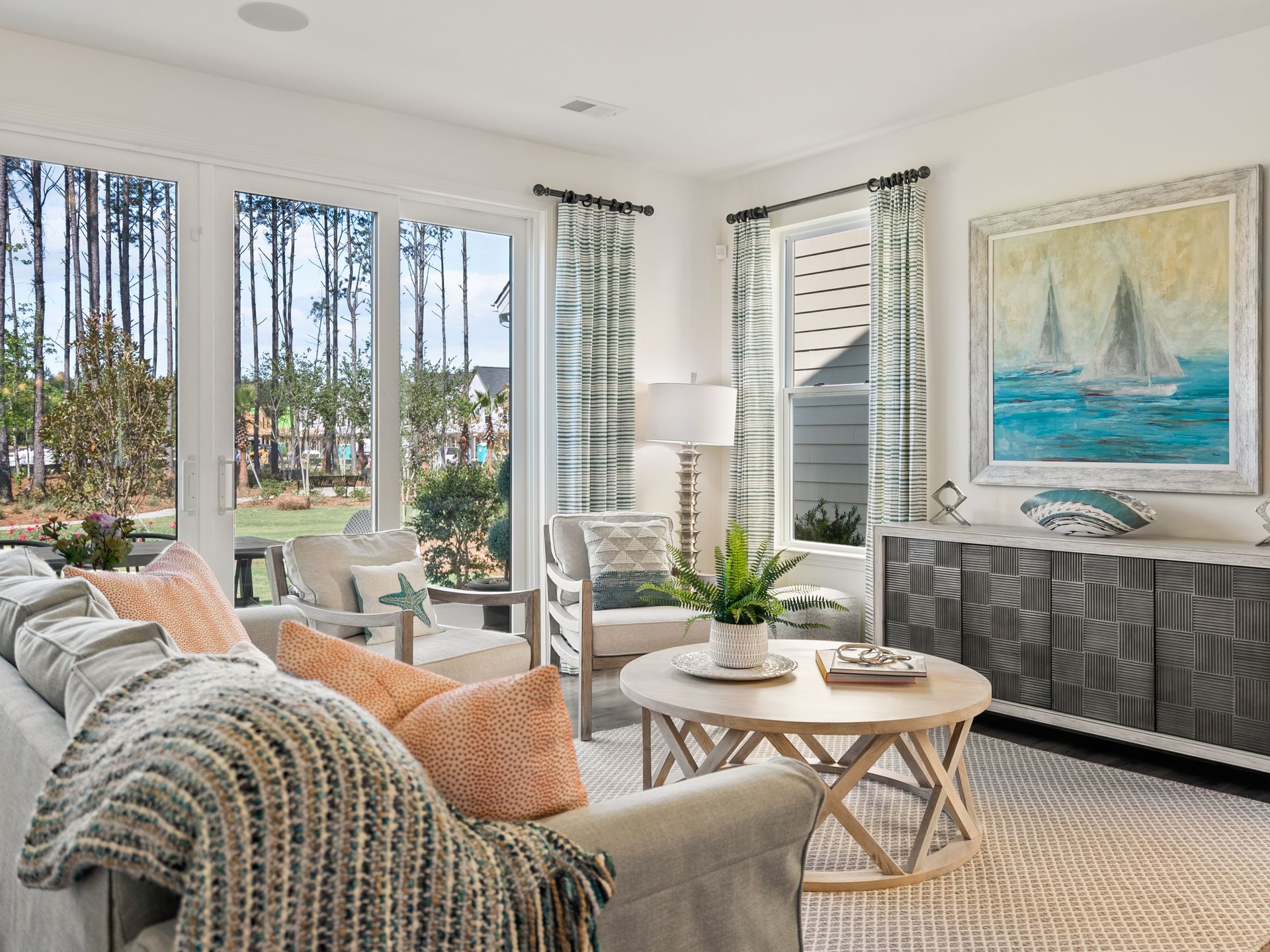 A living room with a couch , table , chairs and a painting on the wall.