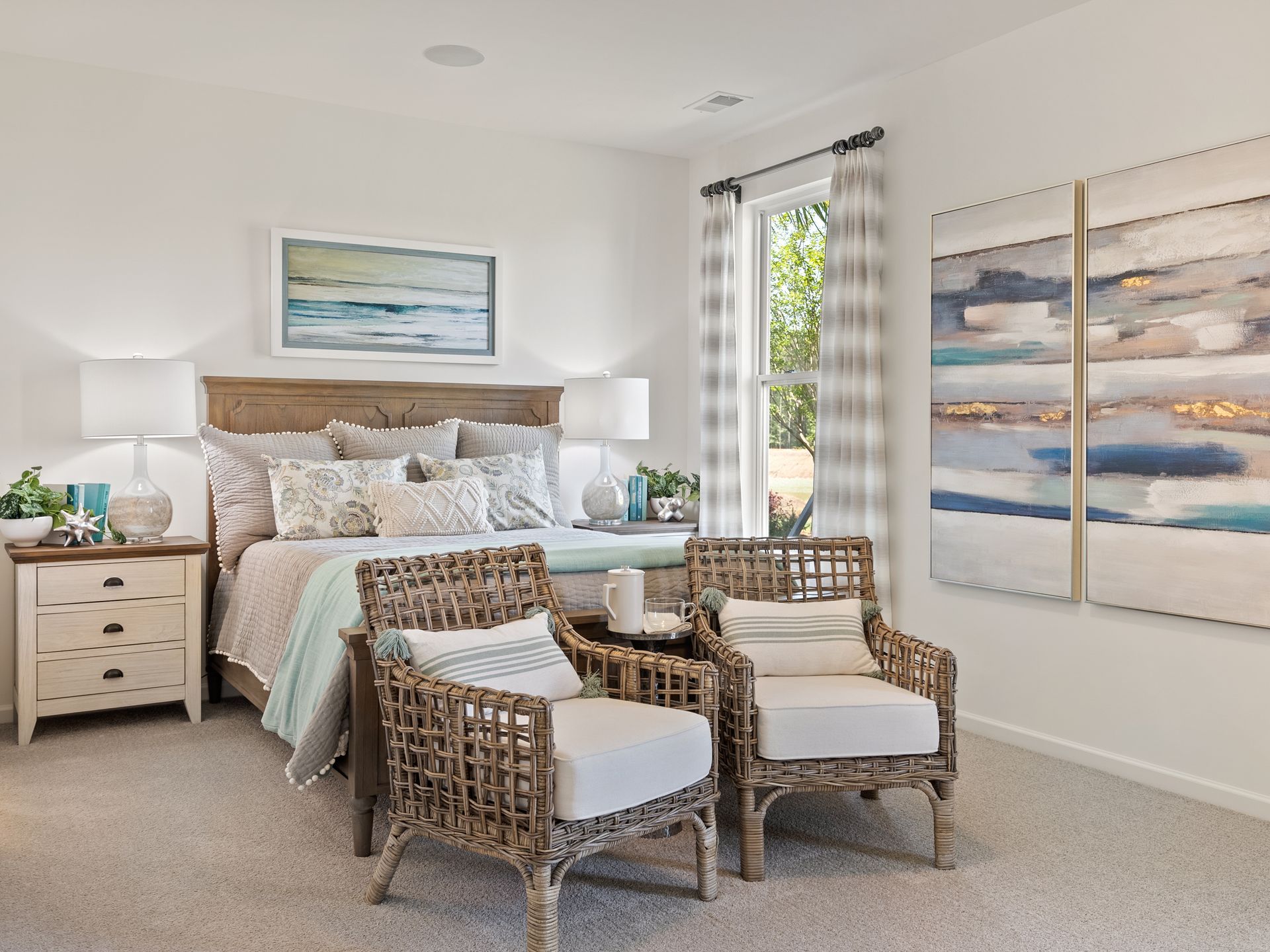 A bedroom with a bed , chairs and paintings on the wall.
