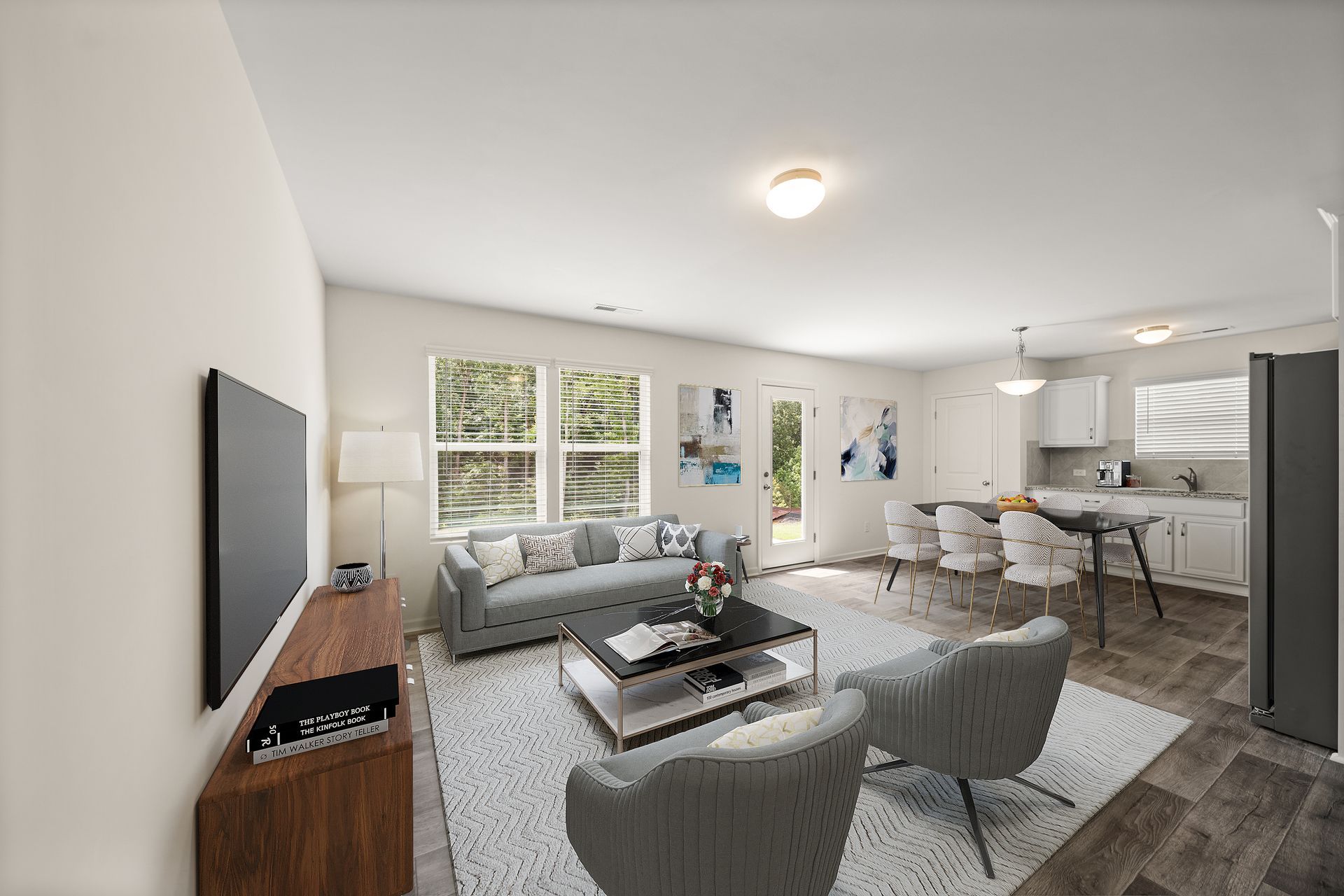 A living room with a couch , chairs , coffee table and television.