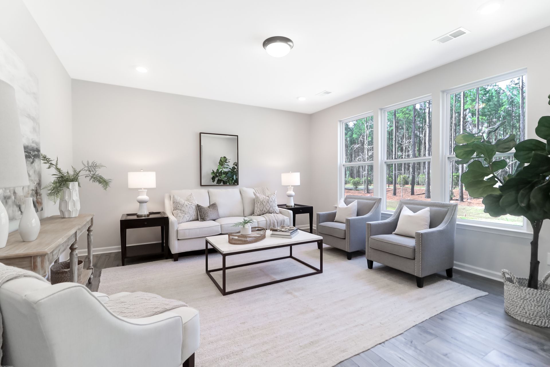 A living room with a couch , chairs , and a coffee table.