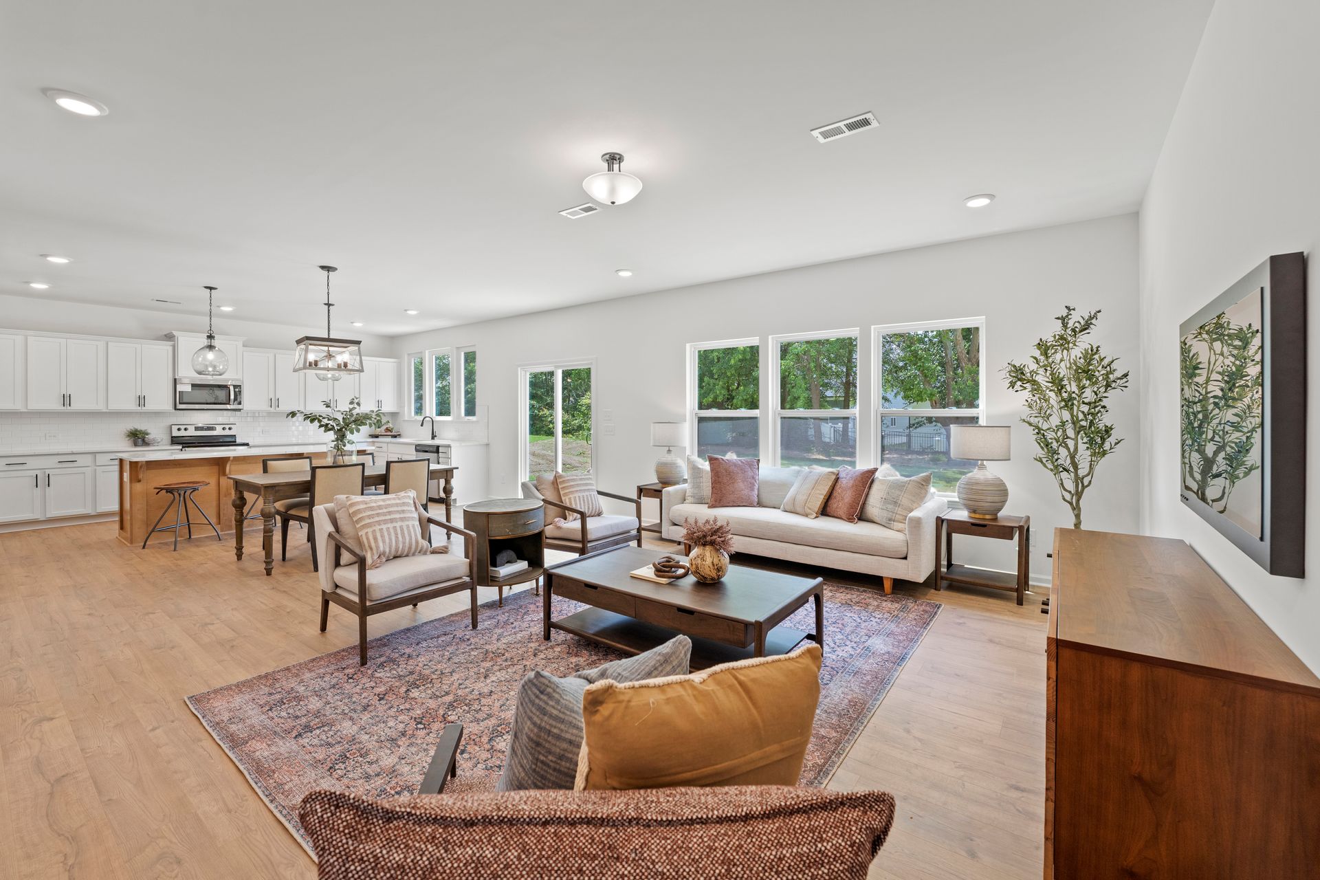 A living room with a couch , chairs , a coffee table and a rug.