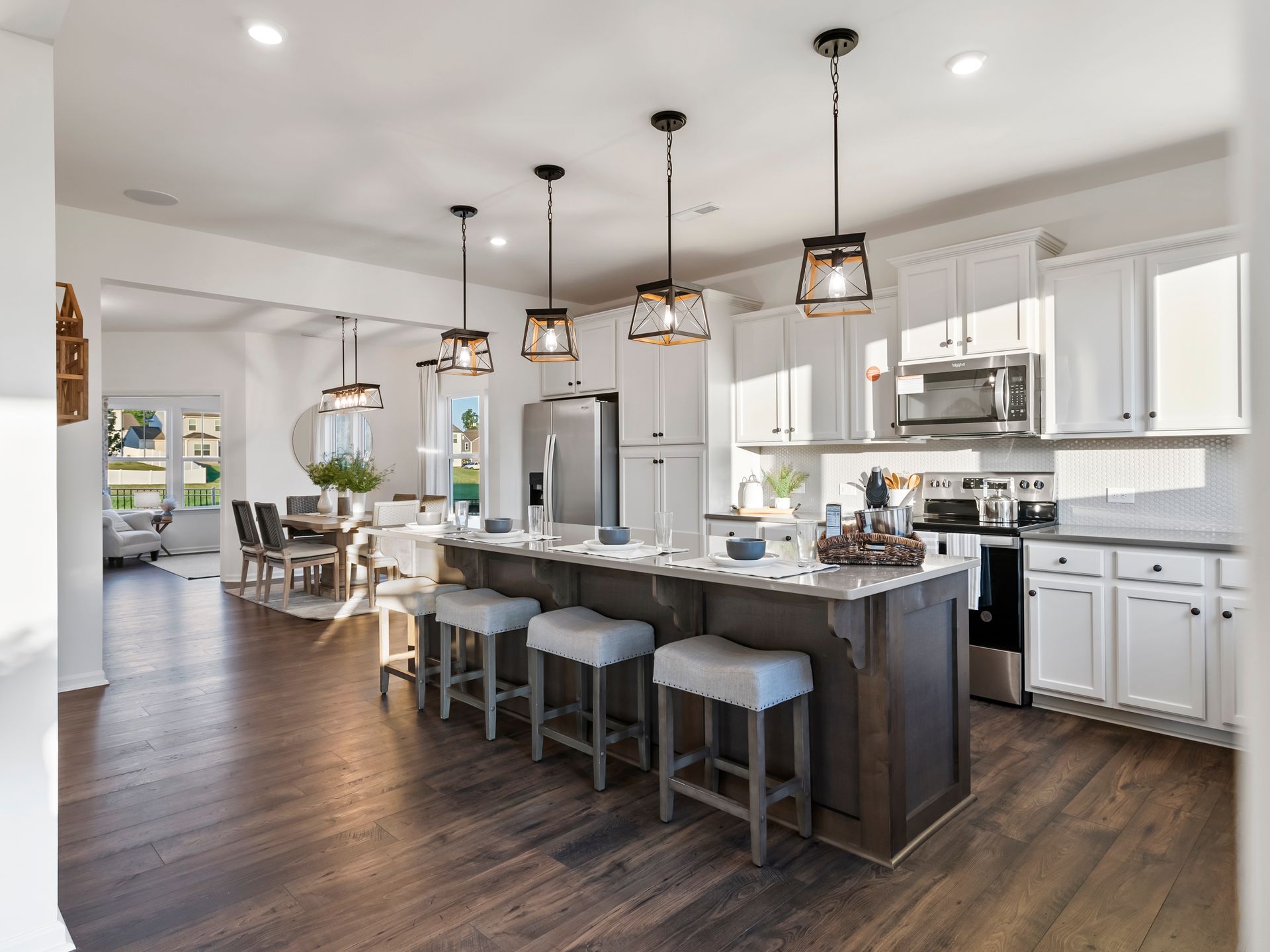 A kitchen with white cabinets , stainless steel appliances and a large island.