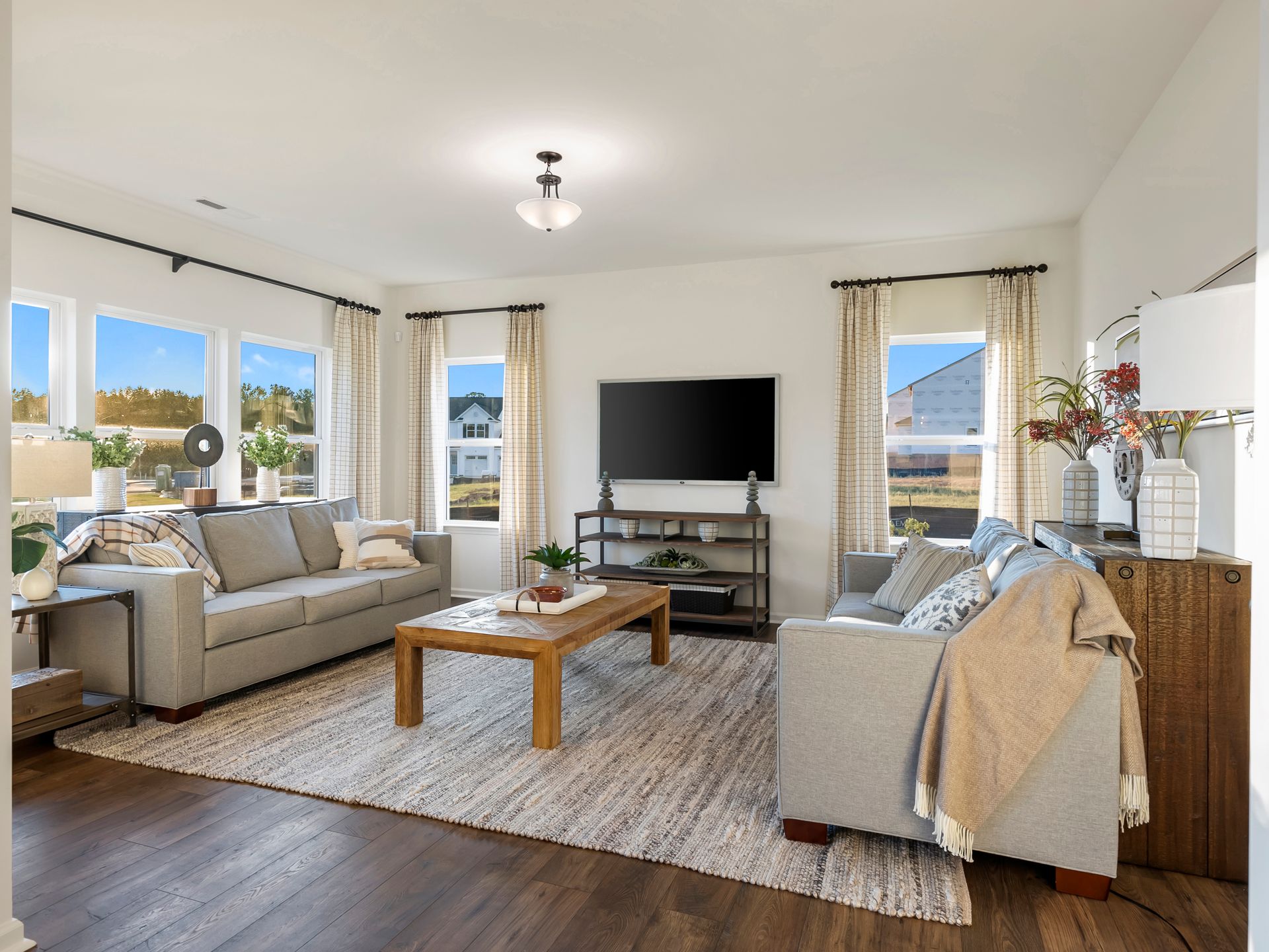 A living room with two couches , a coffee table , and a flat screen tv.