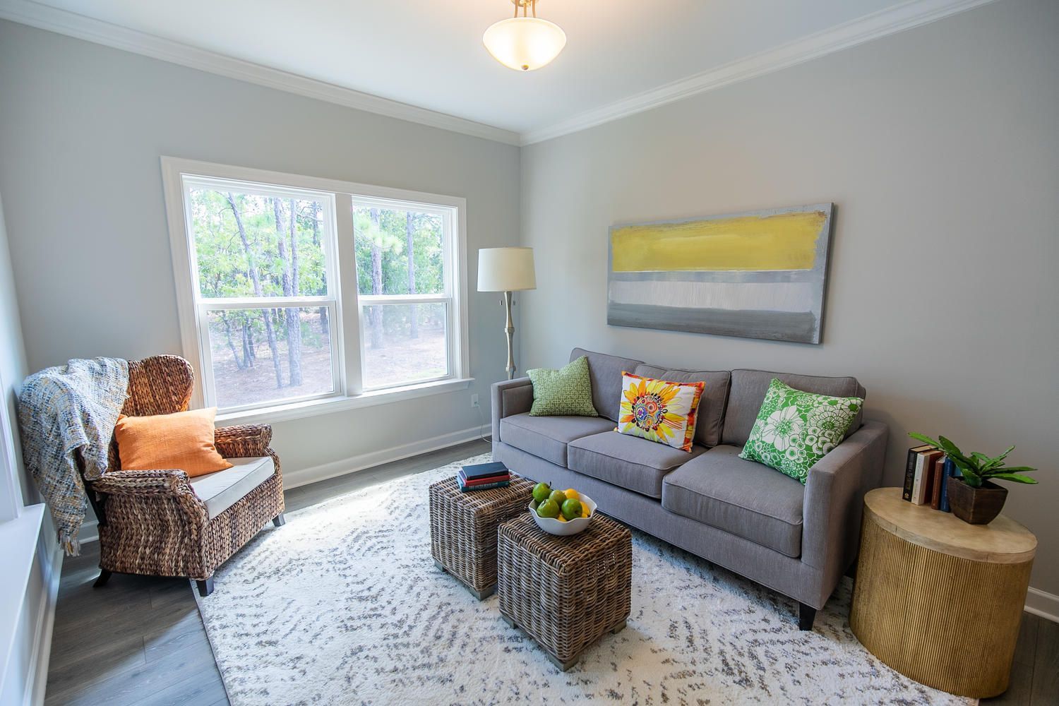 A living room with a couch , chair , coffee table and two windows.
