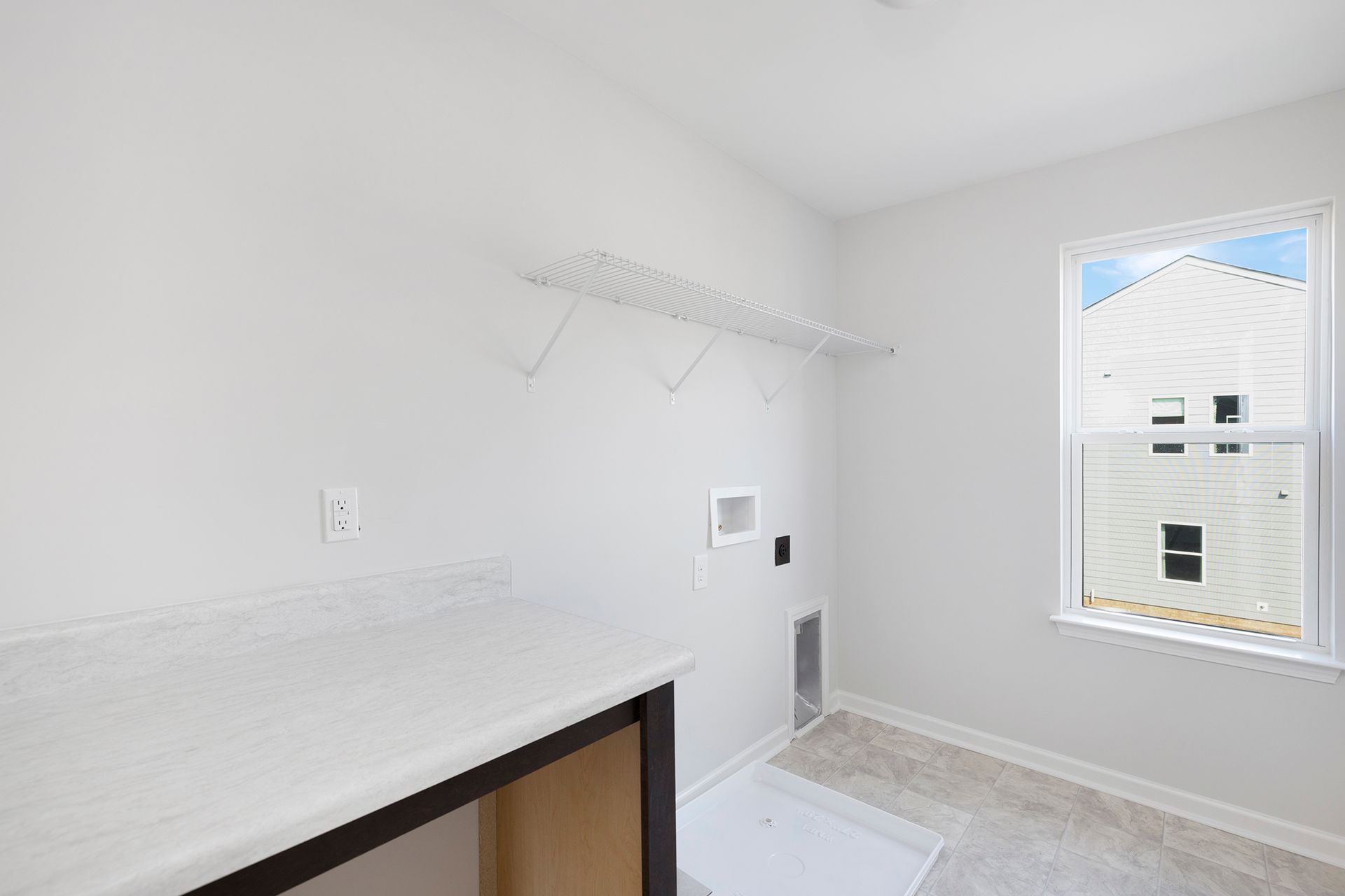 A laundry room with a washer and dryer and a window.