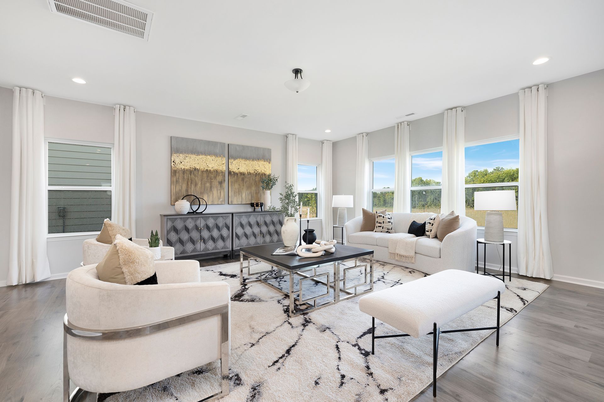 A living room with a couch , chair , coffee table and bench.