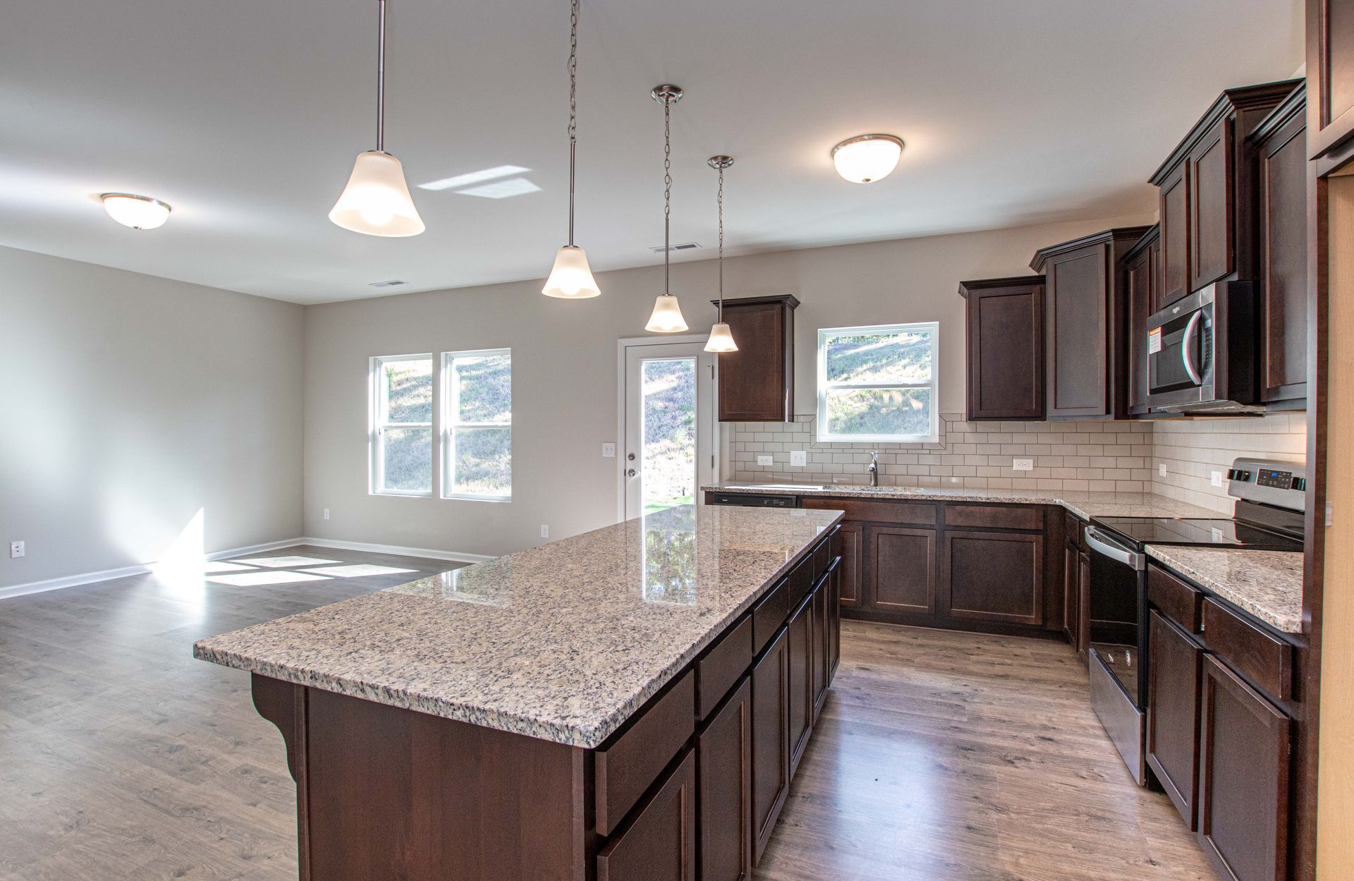 A kitchen with a large island and granite counter tops
