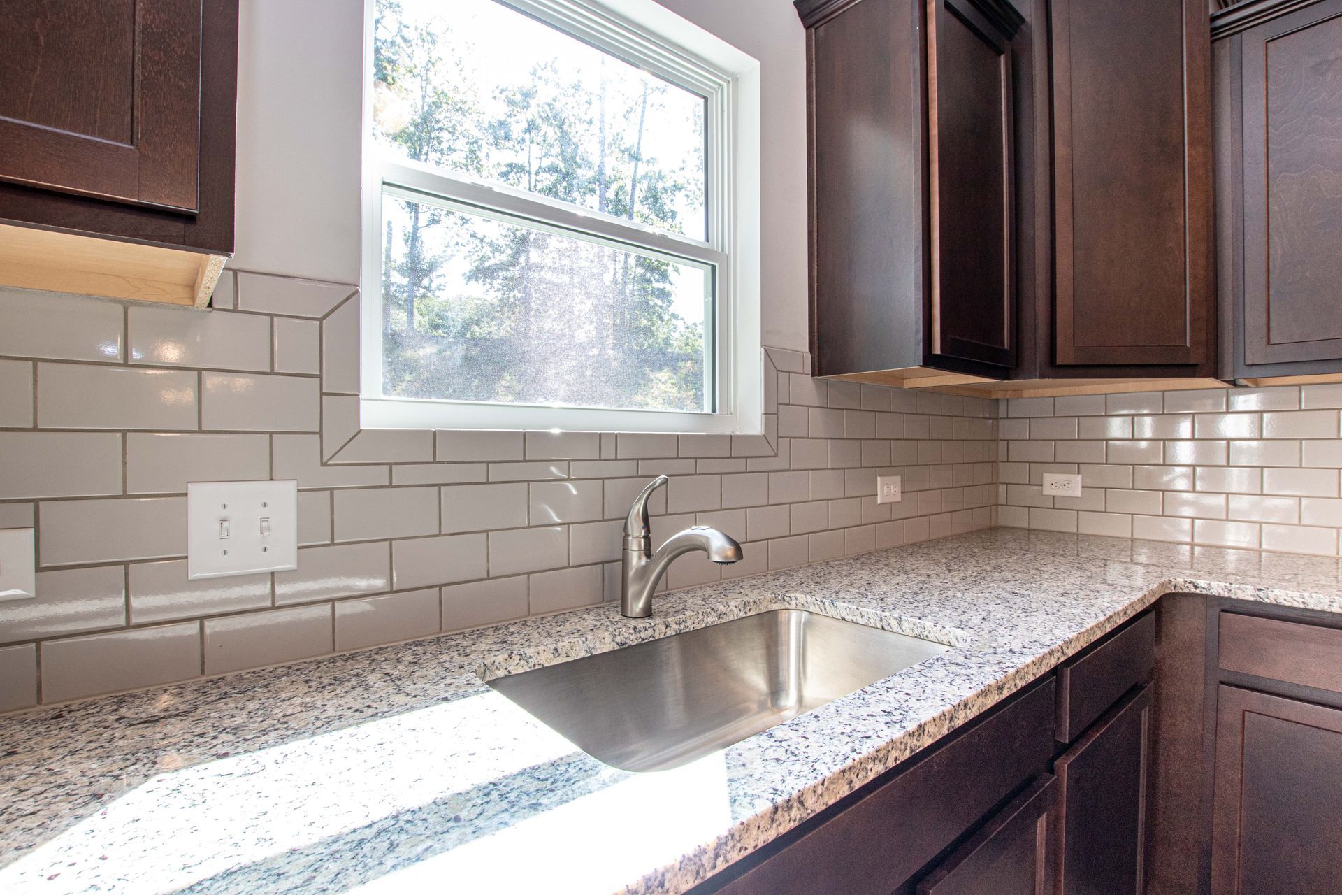 A kitchen with granite counter tops and a stainless steel sink