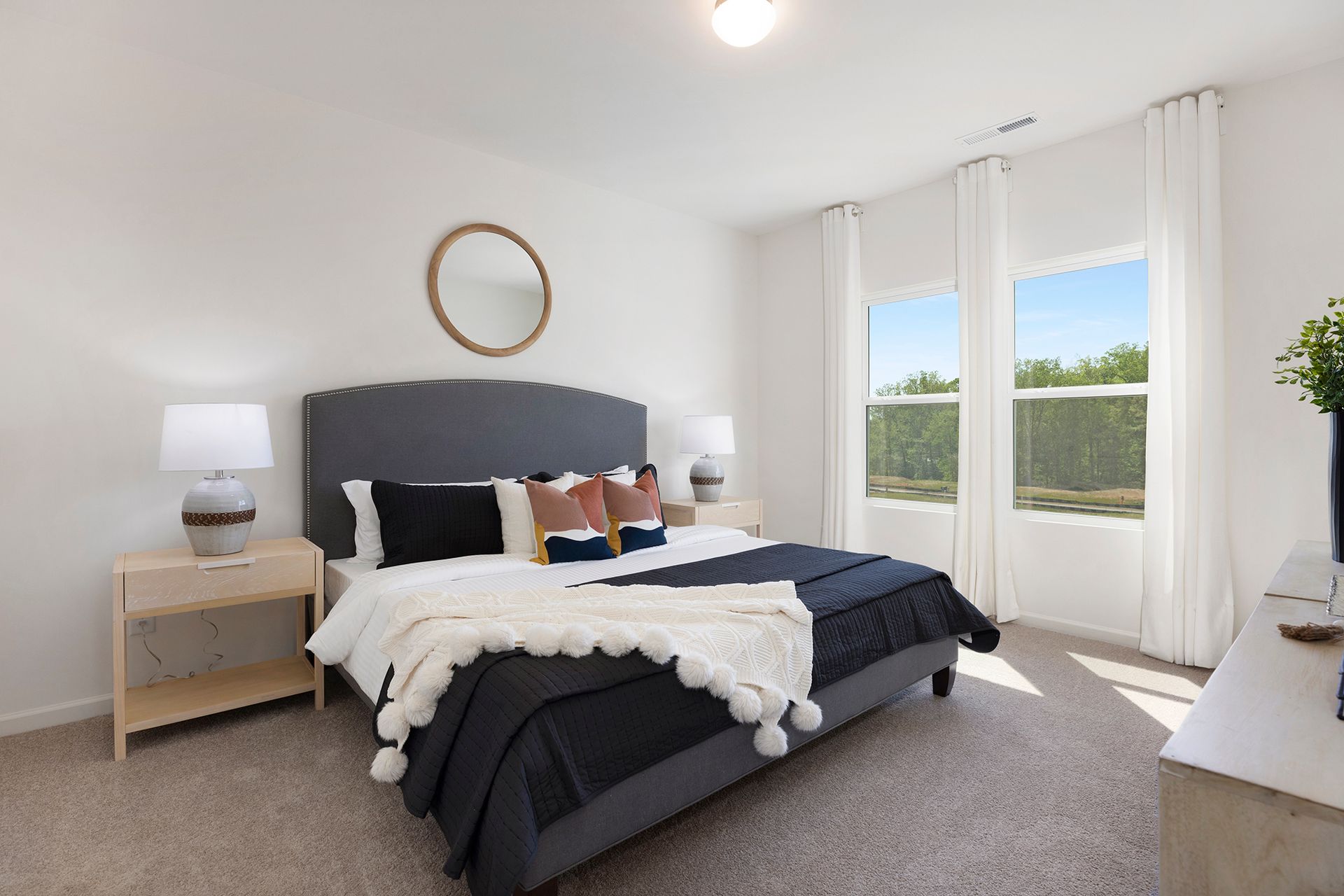 A bedroom with a large bed and two windows