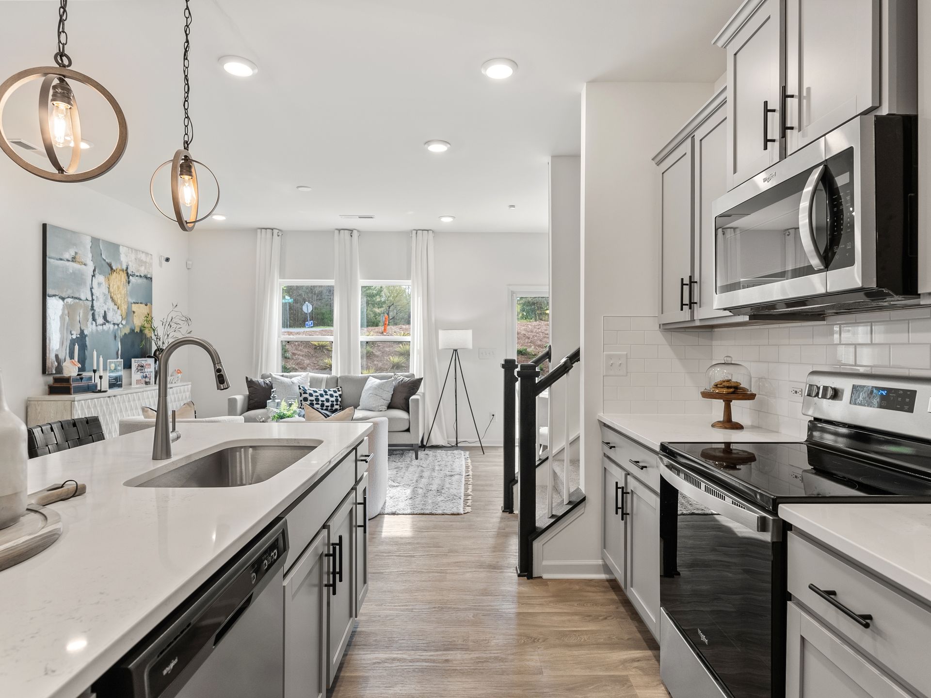 A kitchen with a sink , stove , microwave and dishwasher.