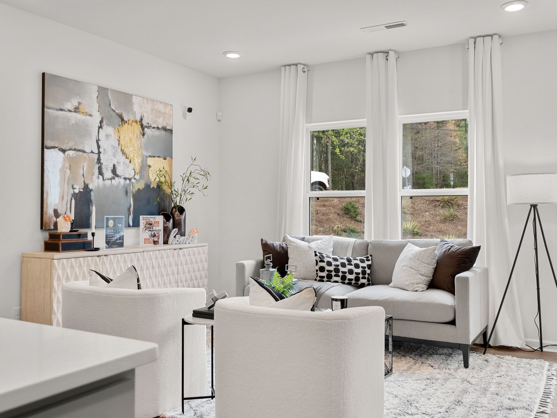 A living room with a couch , chairs , and a painting on the wall.