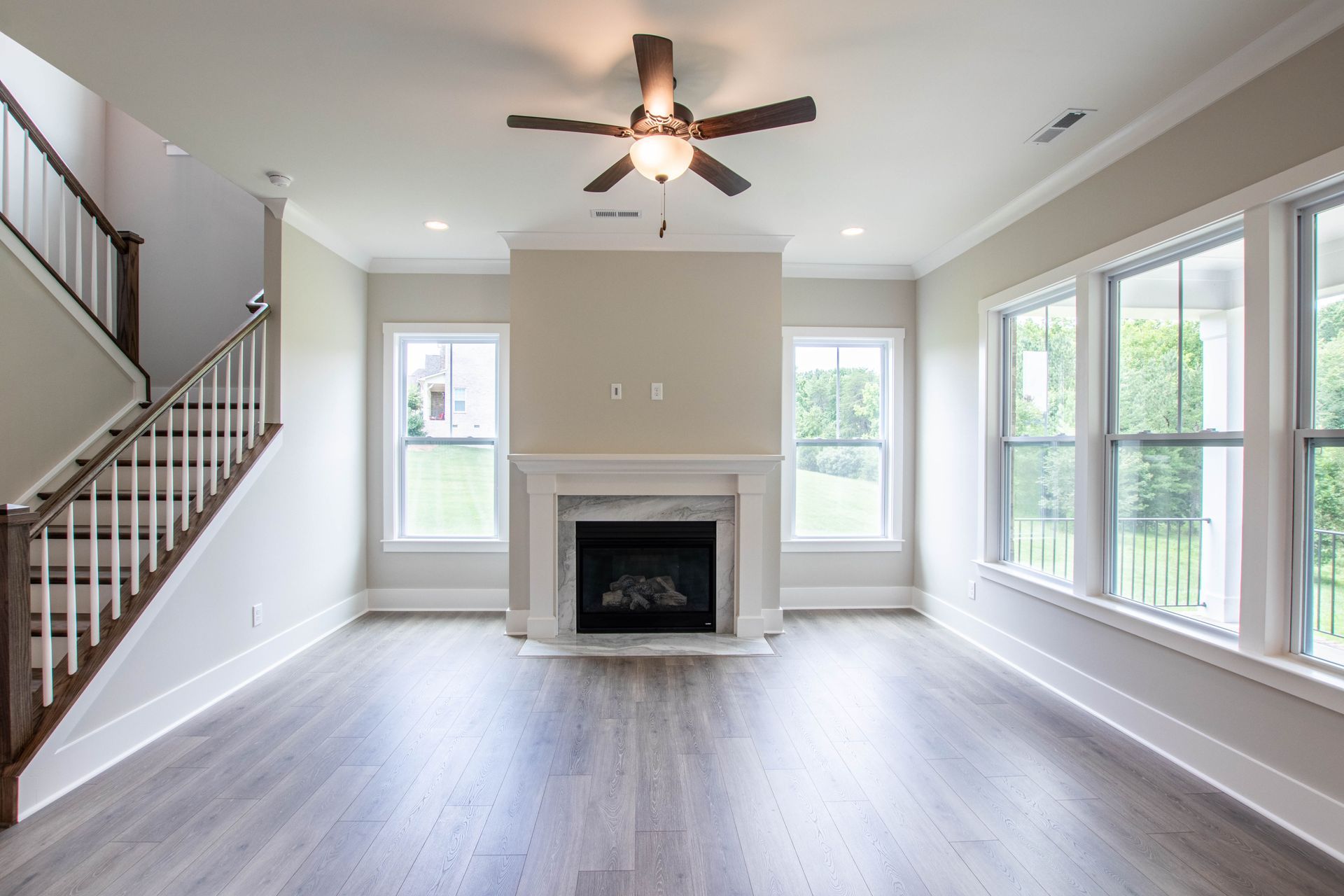 An empty living room with a fireplace and stairs.