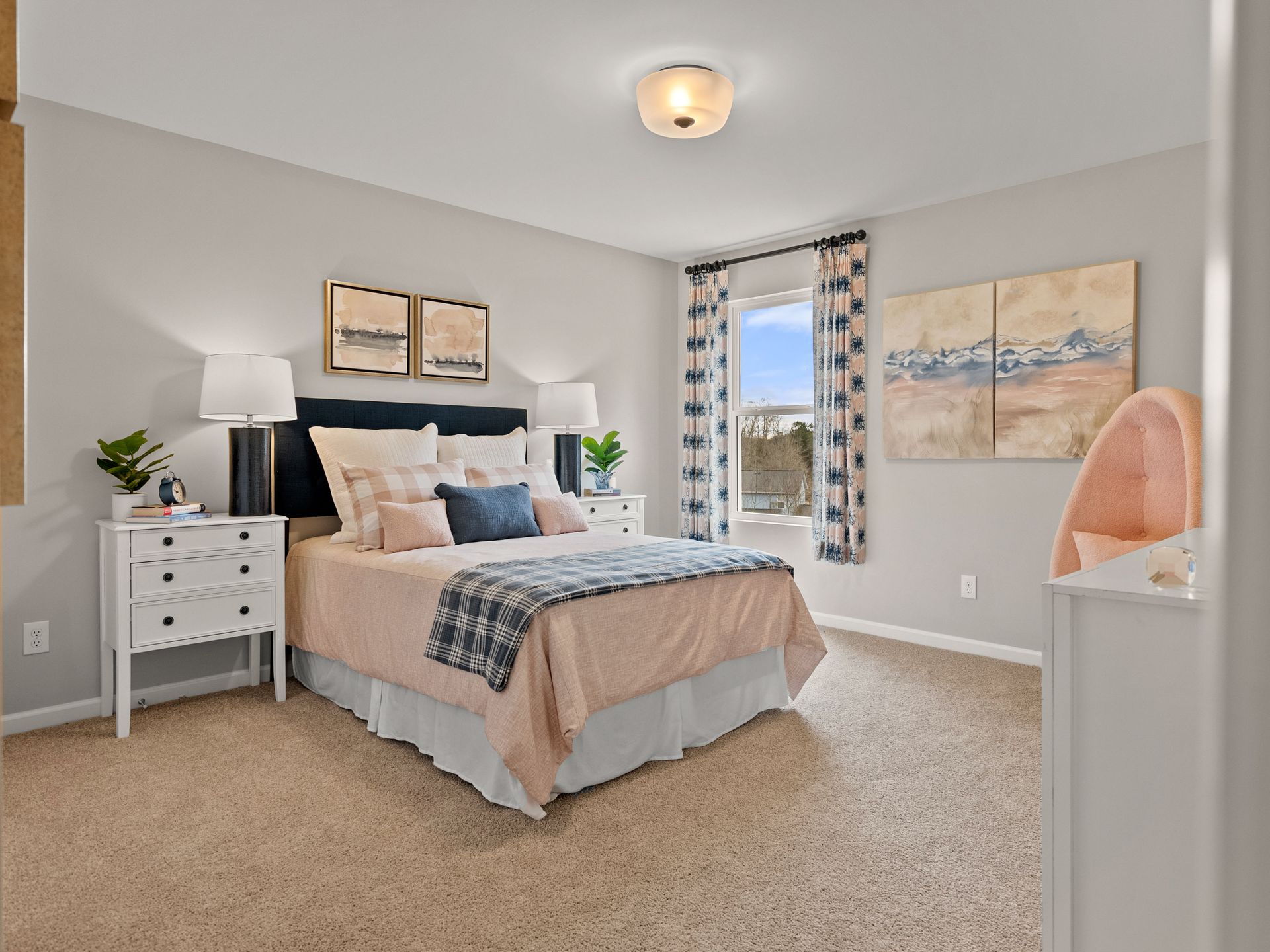 A bedroom with a bed , nightstand , dresser and window.