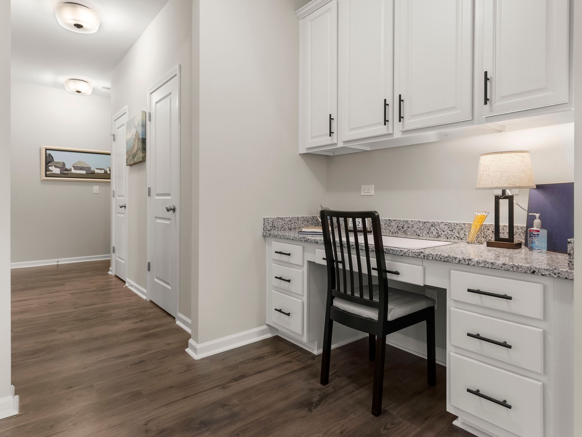 A home office with a desk and chair in a hallway.